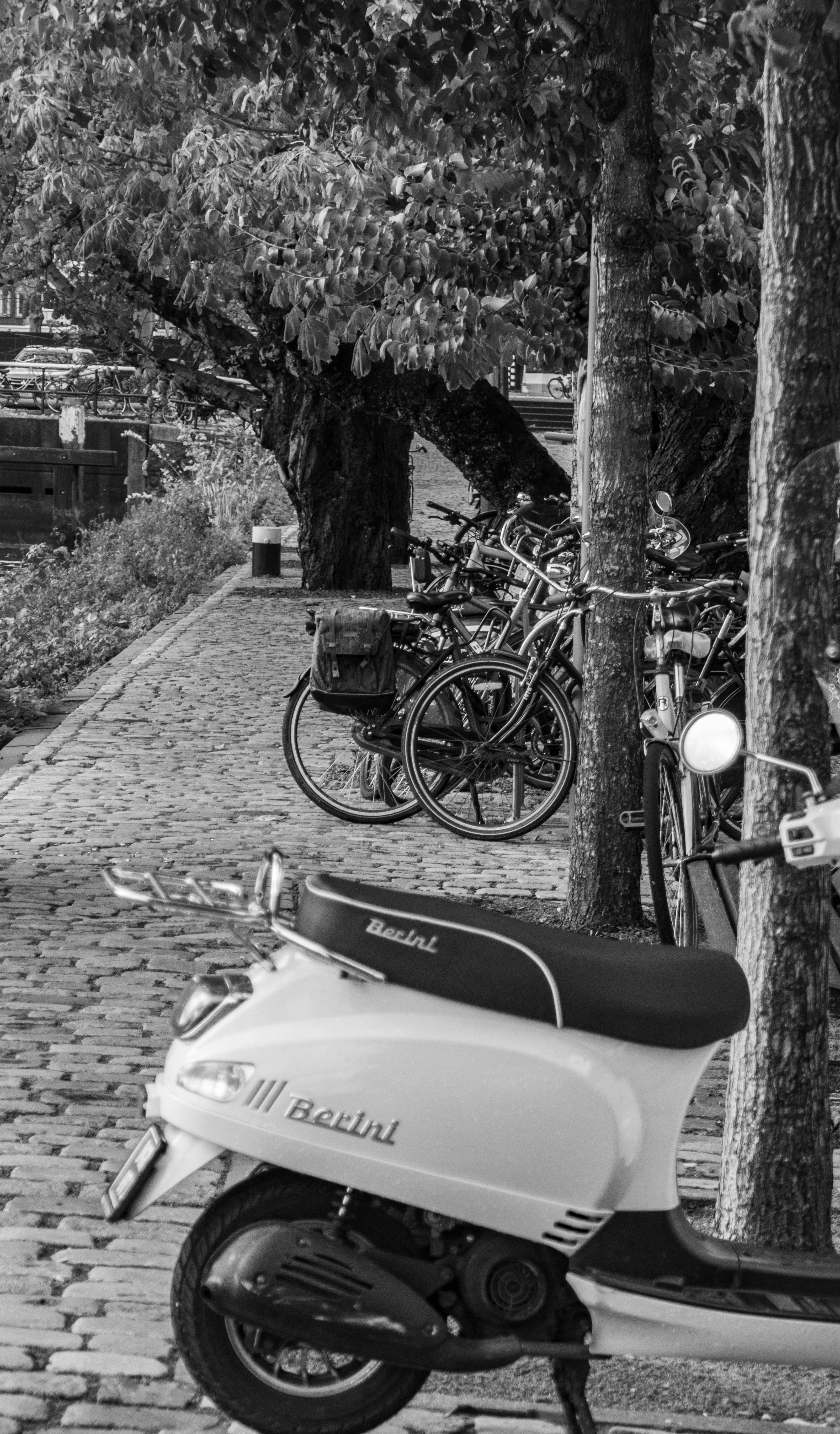 Parked Scooter and Bikes on Cobblestone Path