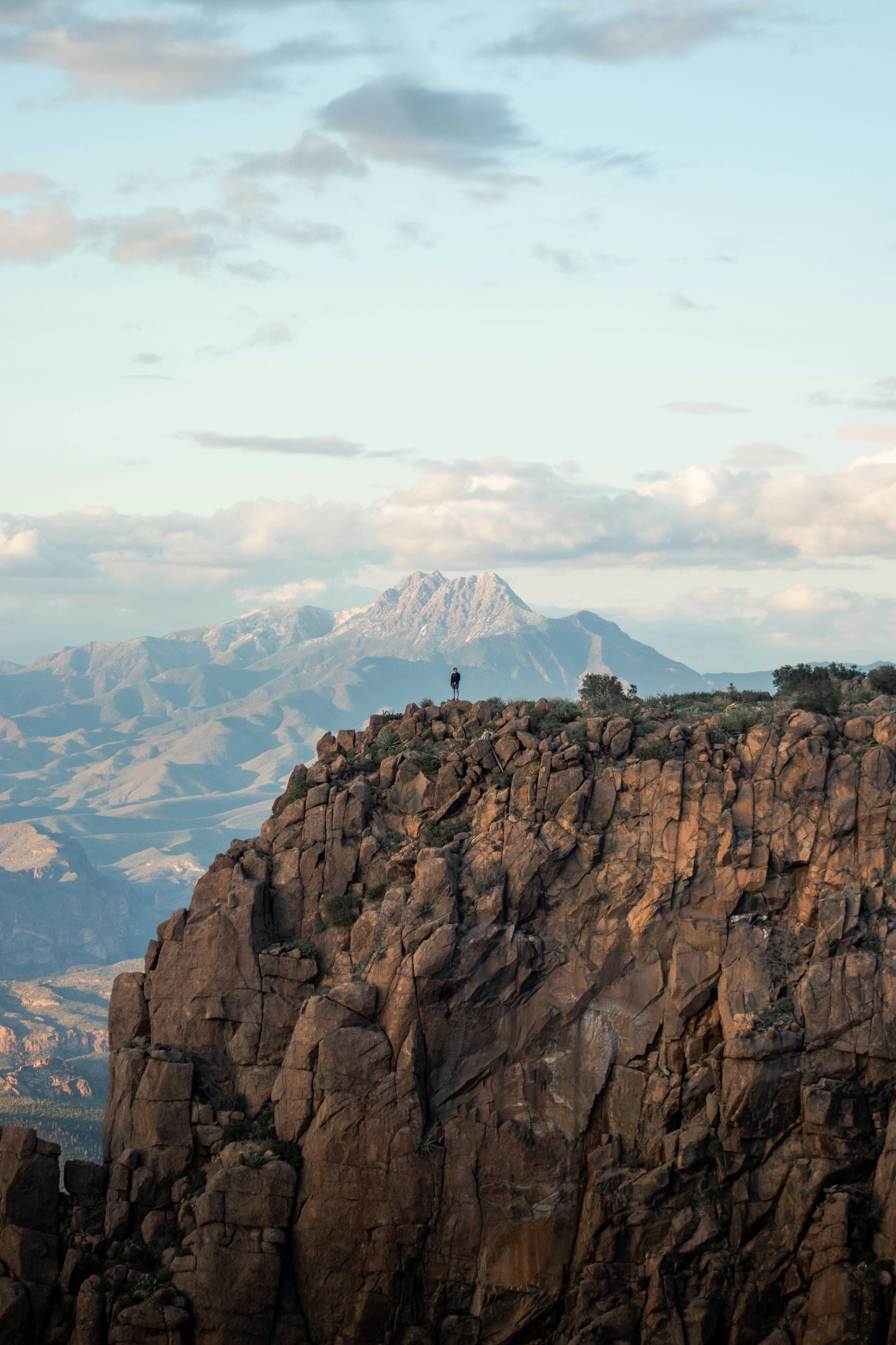 Lone Person on Cliff Overlooking Mountains
