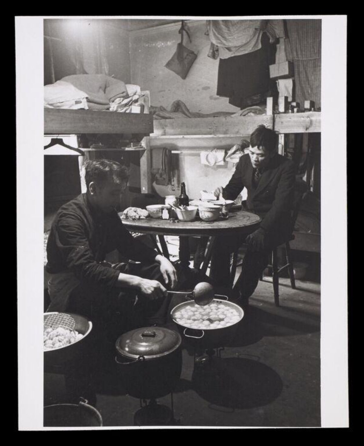 Two Men Boiling Dumplings in Shared Quarters