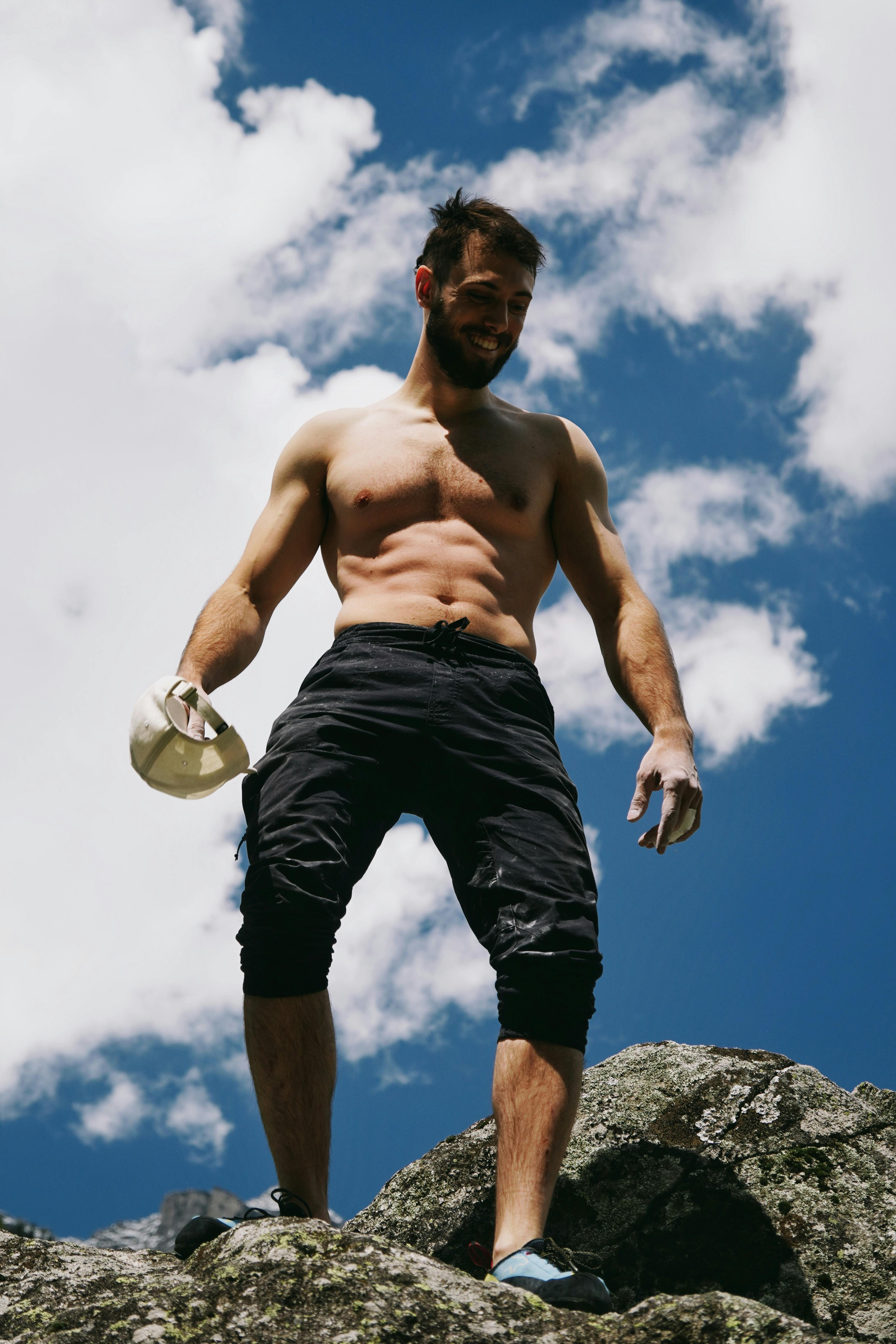 Shirtless Climber On Rocky Outcrop