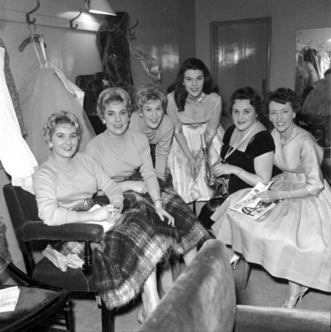 Six women in backstage dressing room