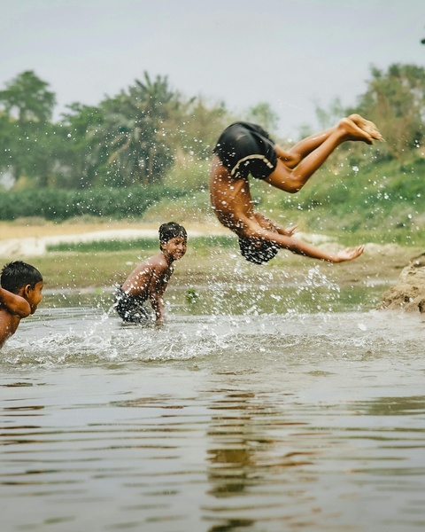 Boys Diving Into River Water