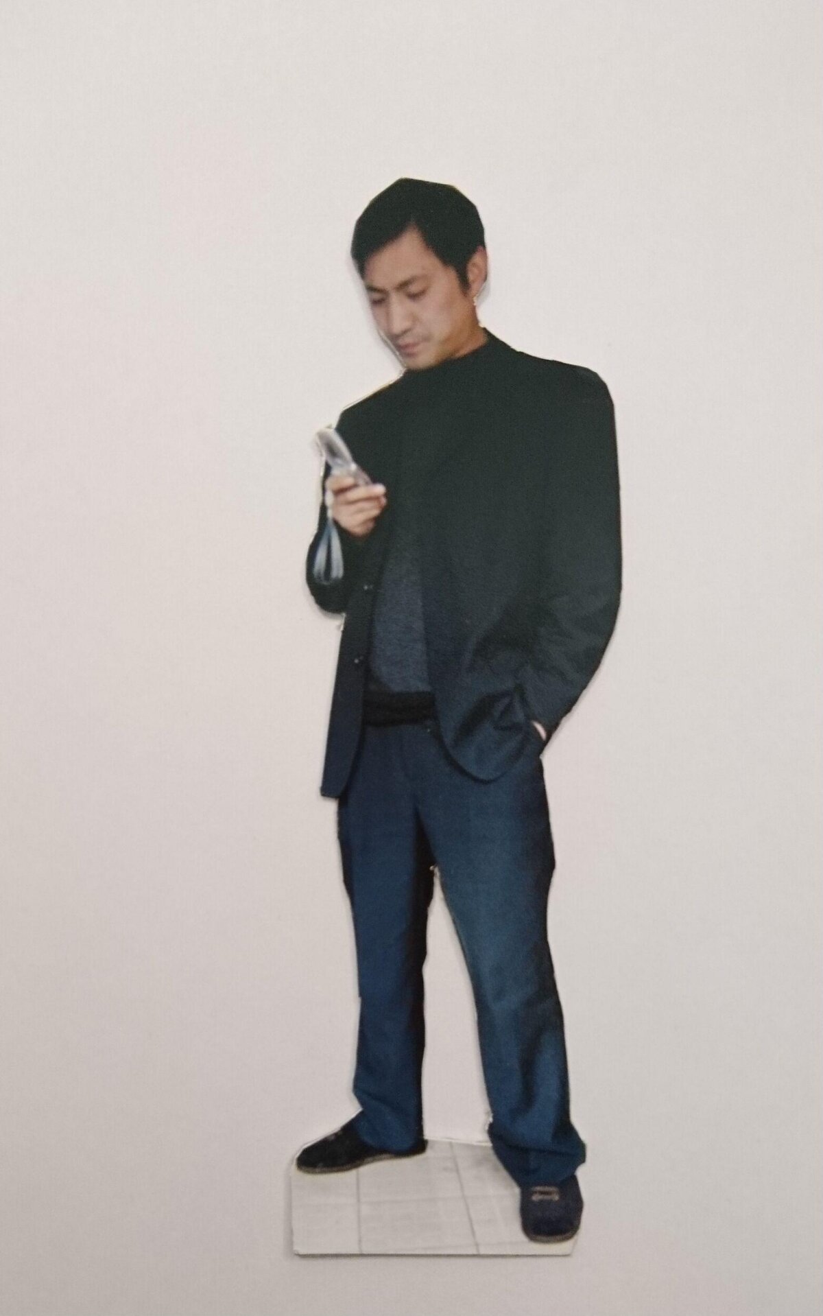 Cardboard Cutout of Man Looking at Phone
