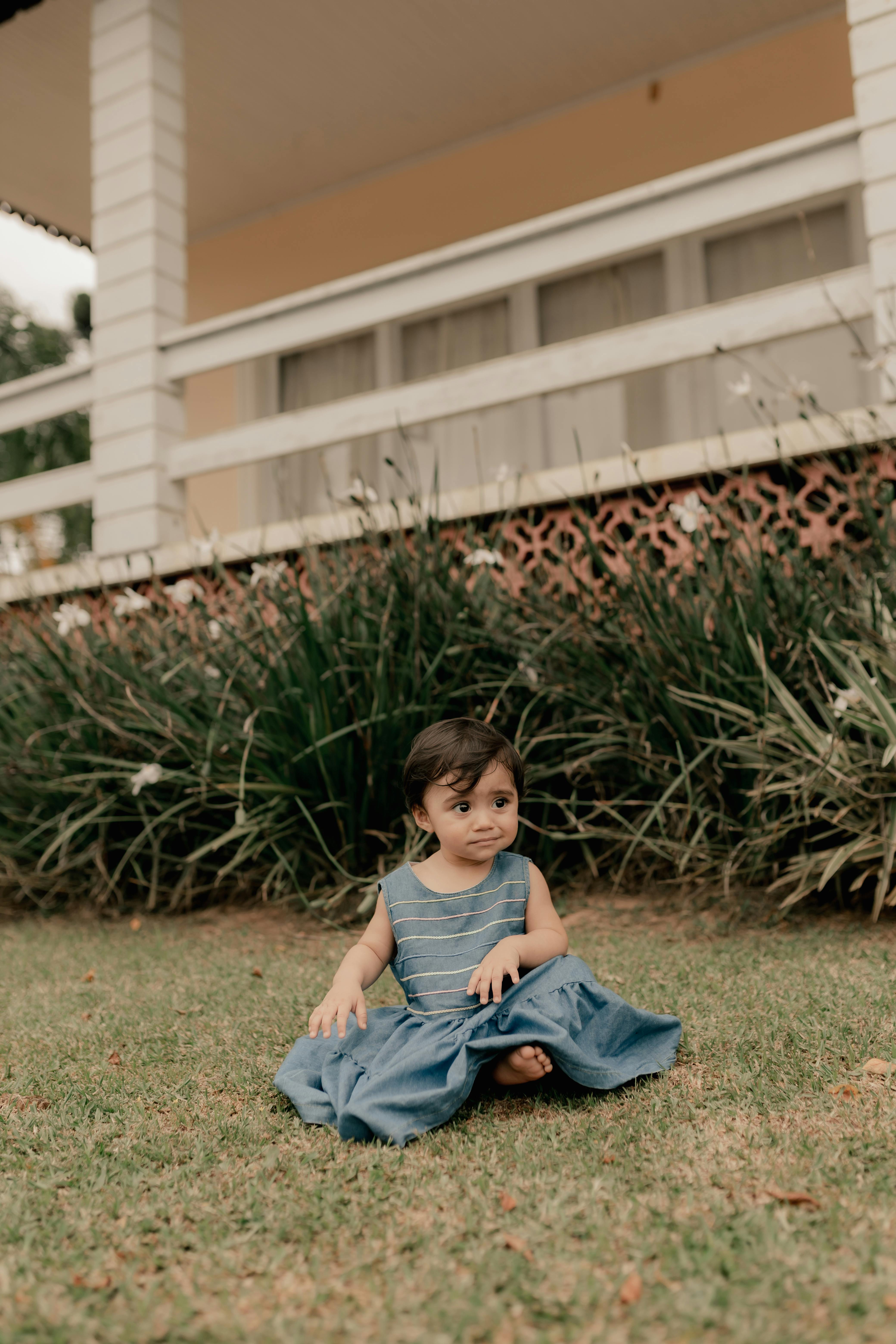 Toddler Girl Sitting on Garden Lawn