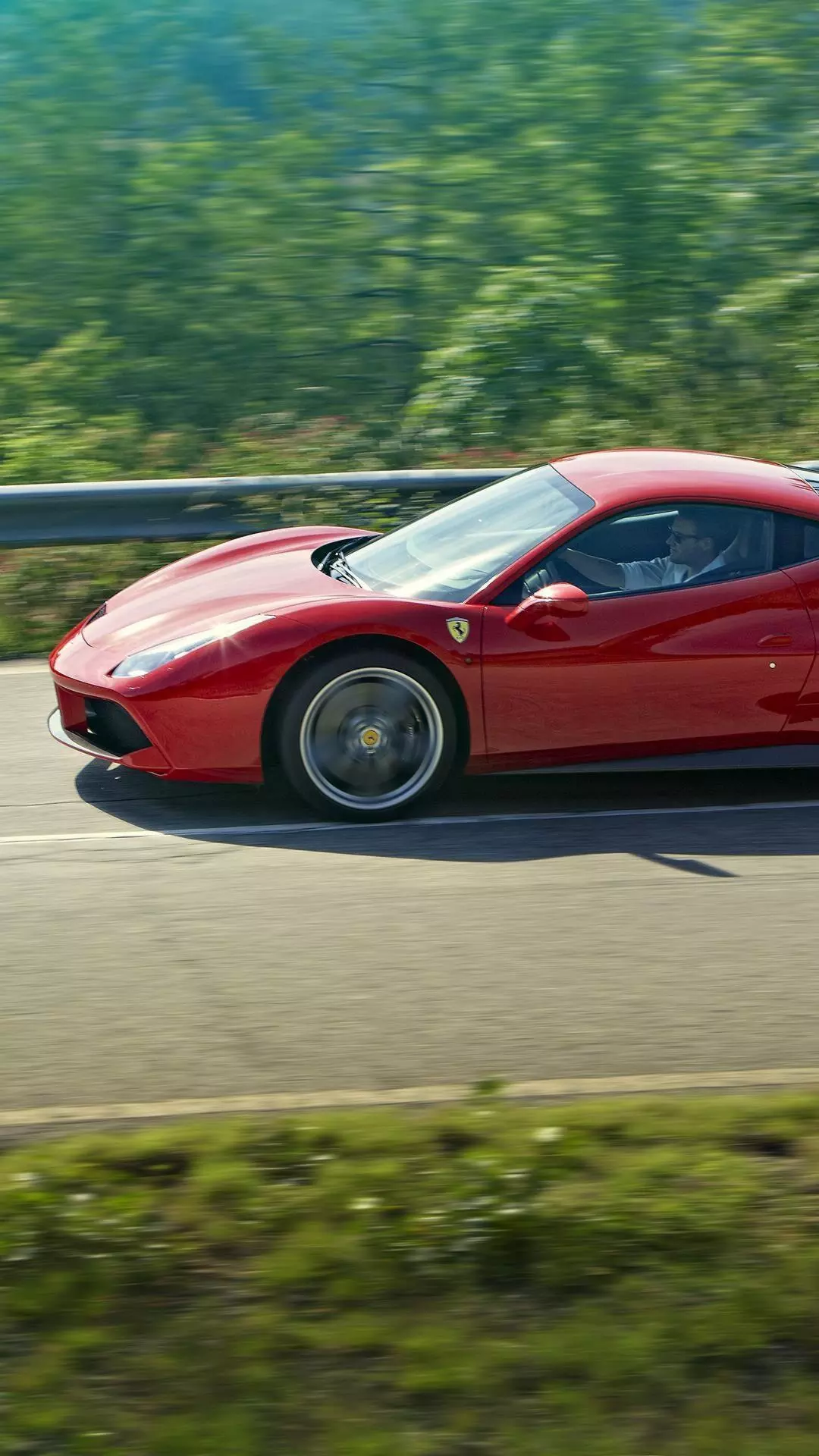 Red Ferrari Driving on Scenic Road