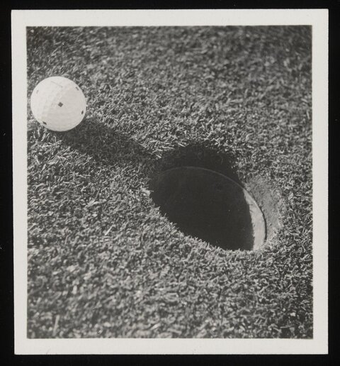 Golf Ball Next to Golf Hole