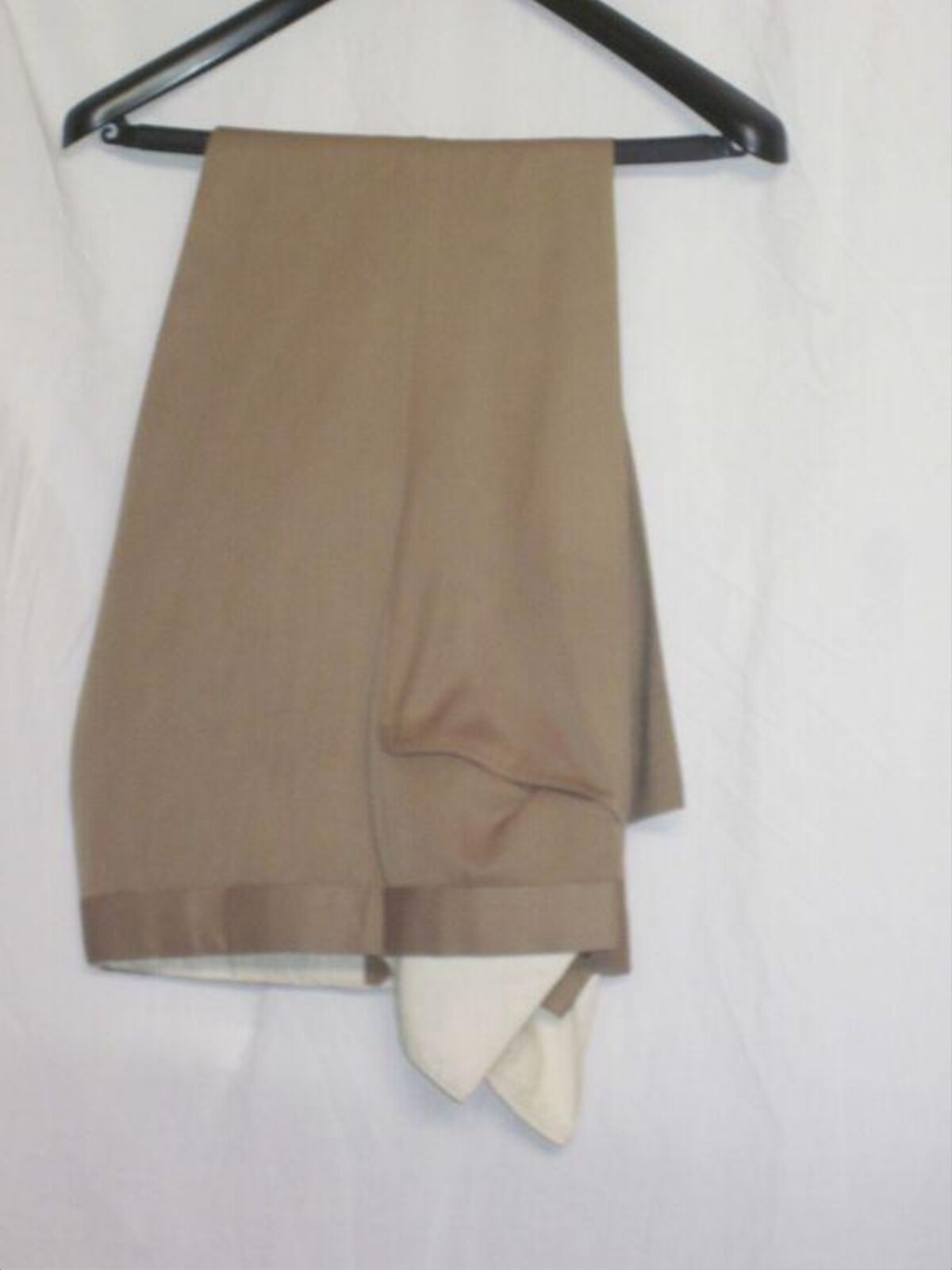 Folded Camel Trousers on Black Hanger