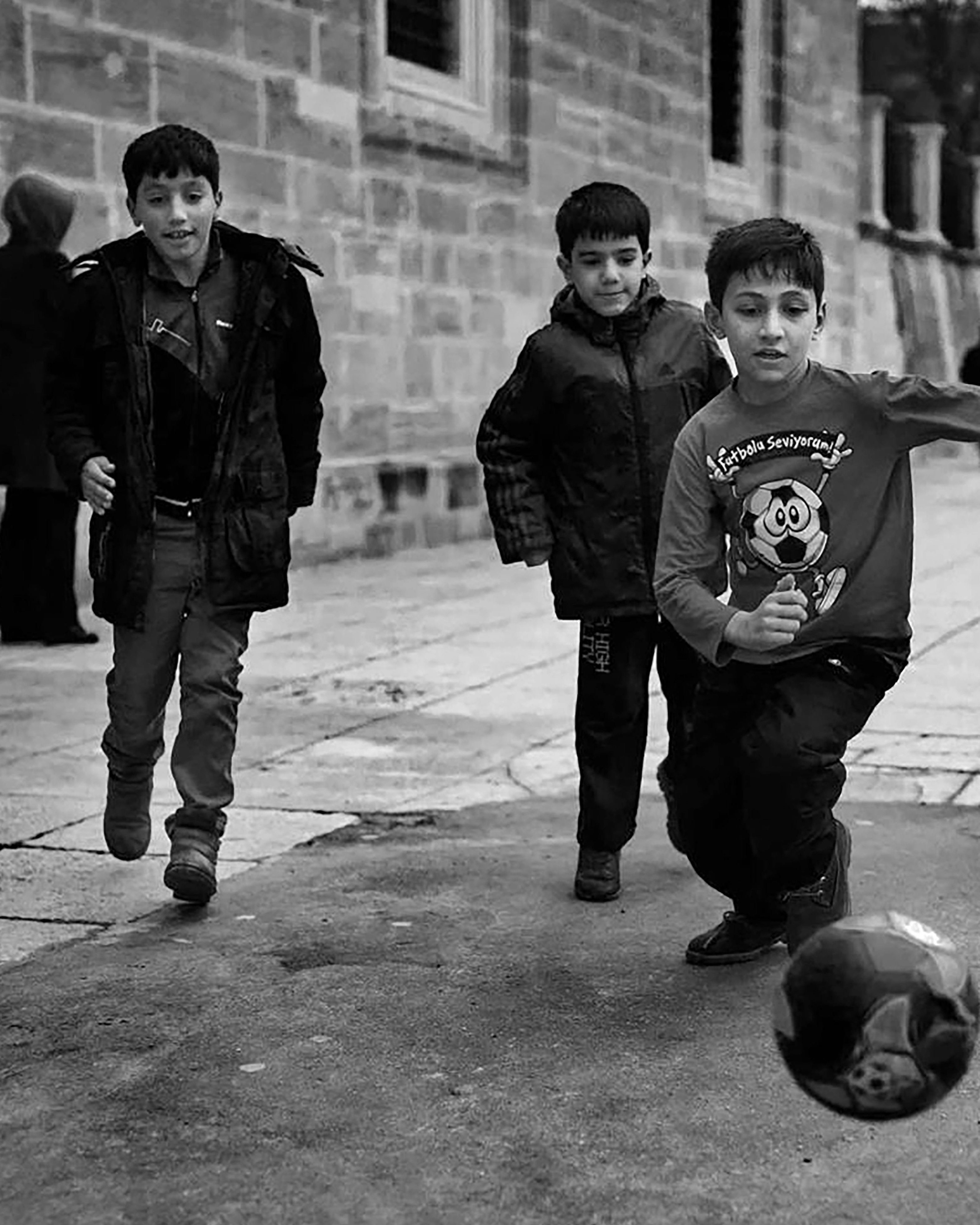 Three Boys Playing Street Soccer