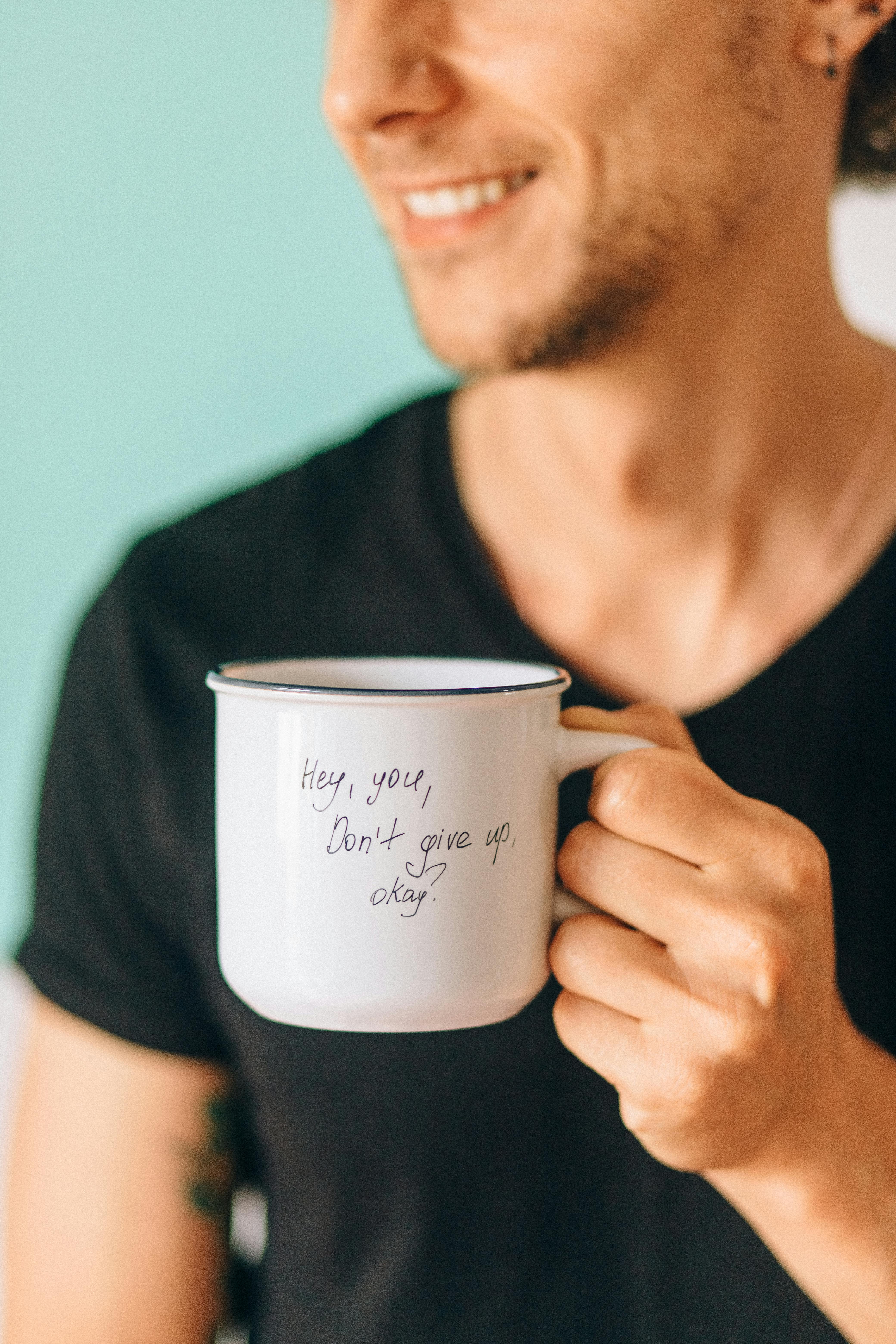 Smiling Man Holding Motivational Message Mug