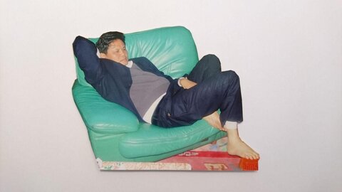 Man Relaxing on Green Leather Sofa