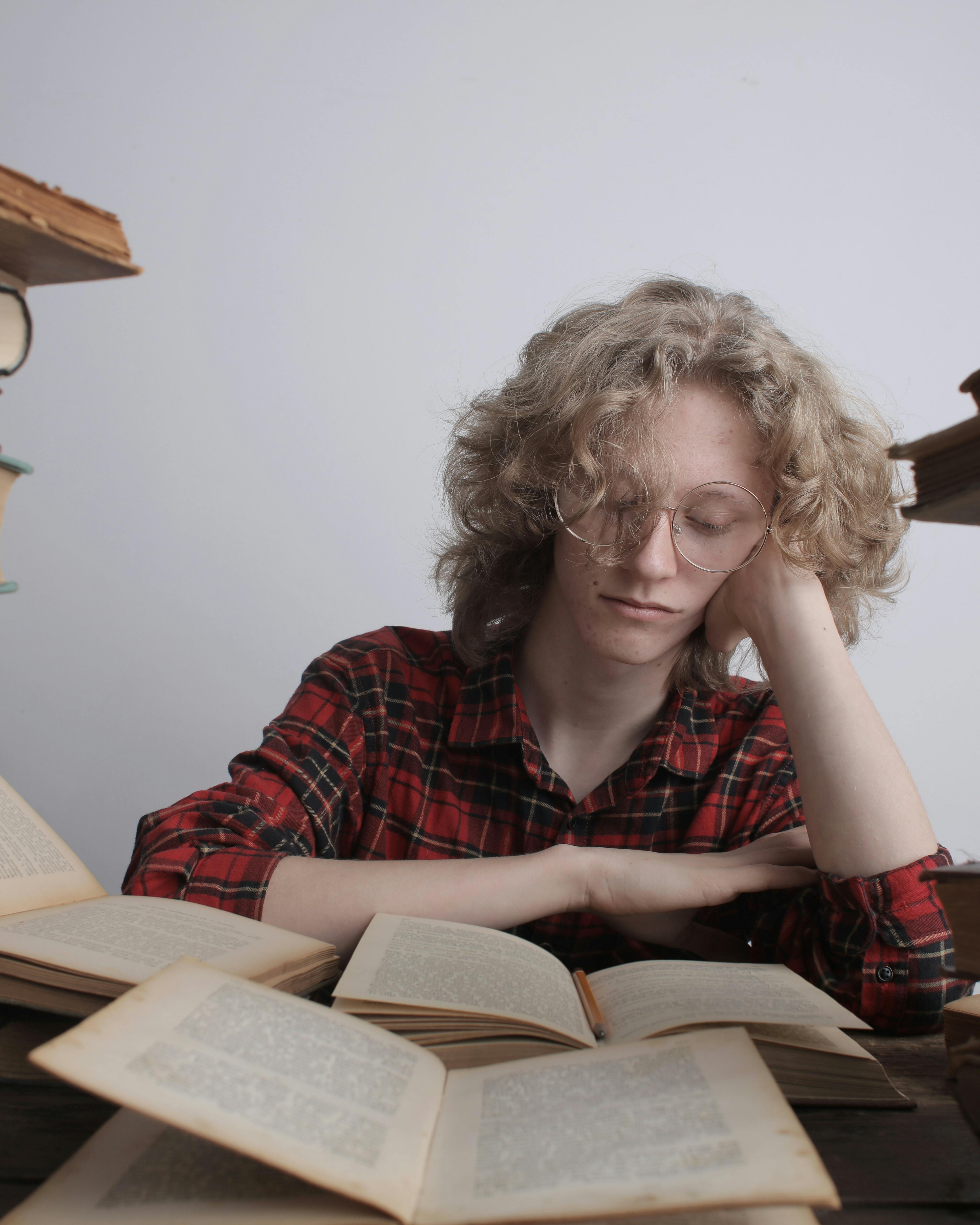 Sleepy Student Resting Over Open Books