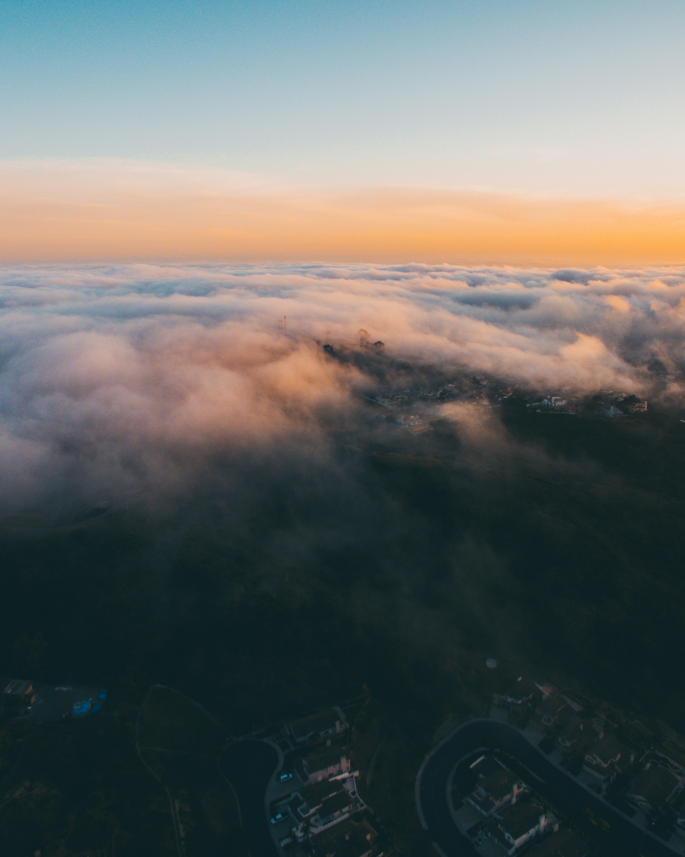 Hillside Neighborhood Above Clouds At Sunset