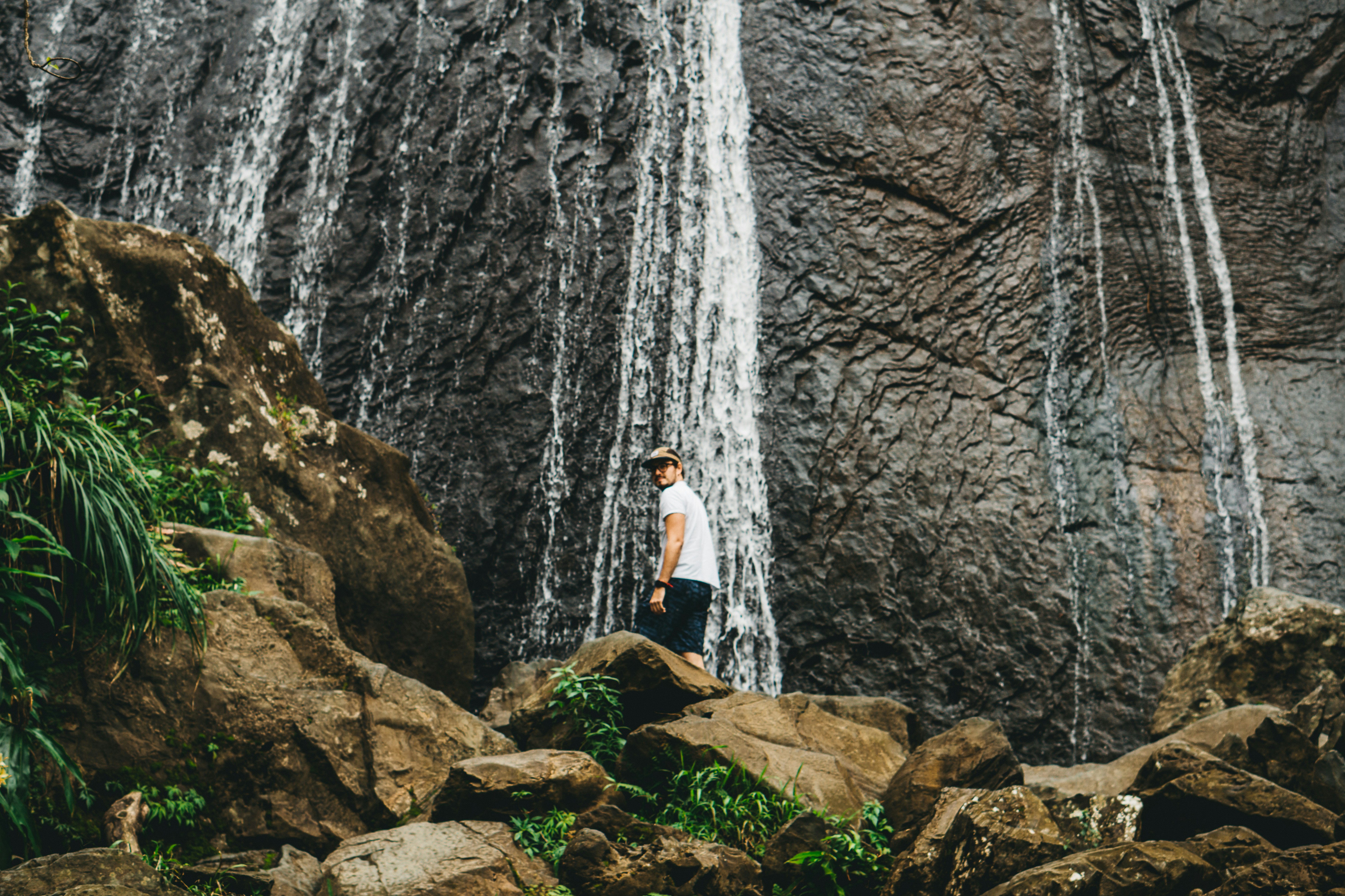 Hiker Standing at Waterfall Base