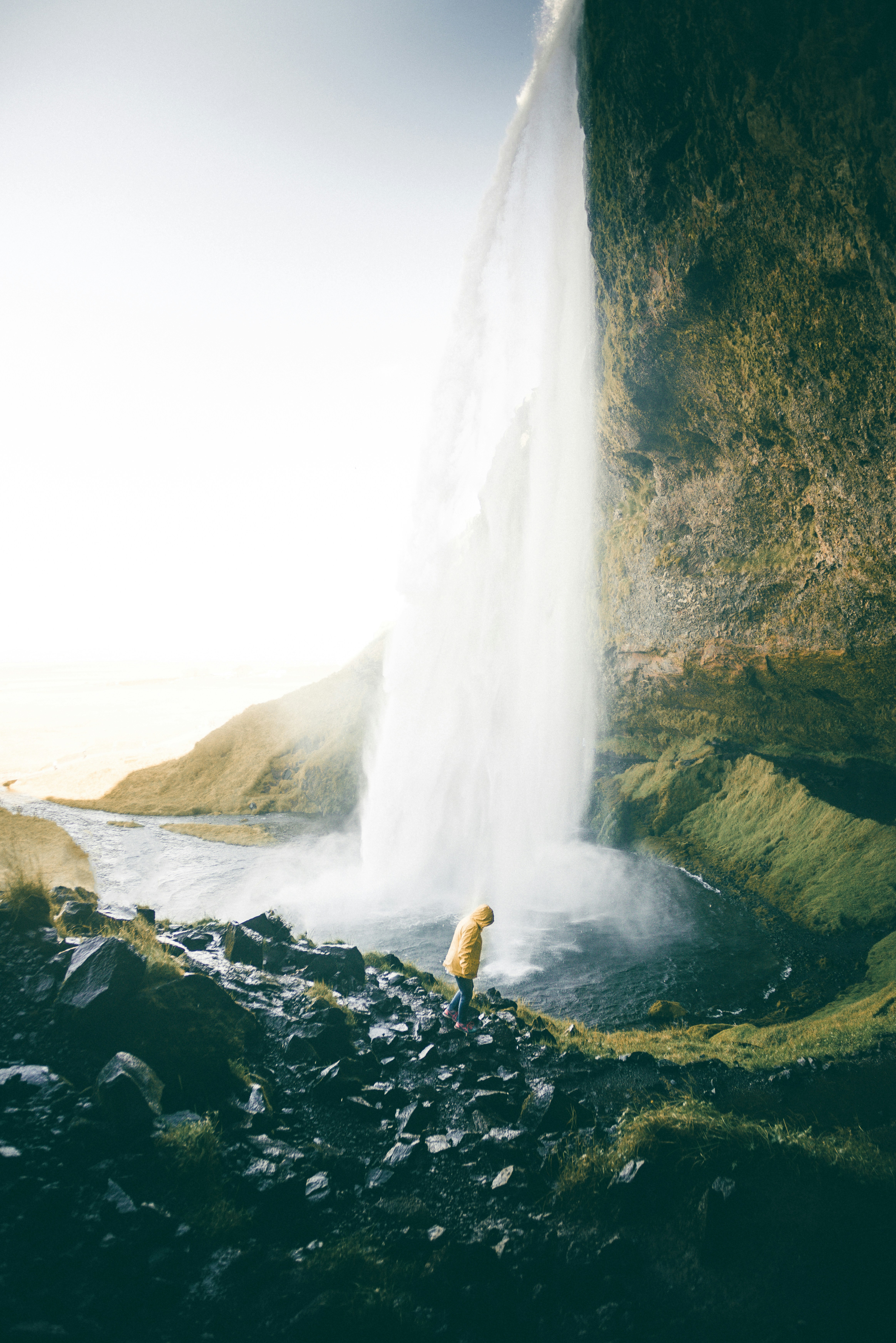 Hiker At The Base Of A Large Waterfall