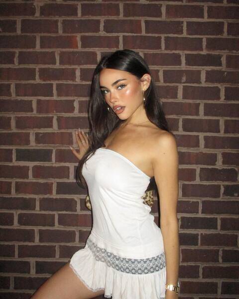Woman in White Dress Against Brick Wall