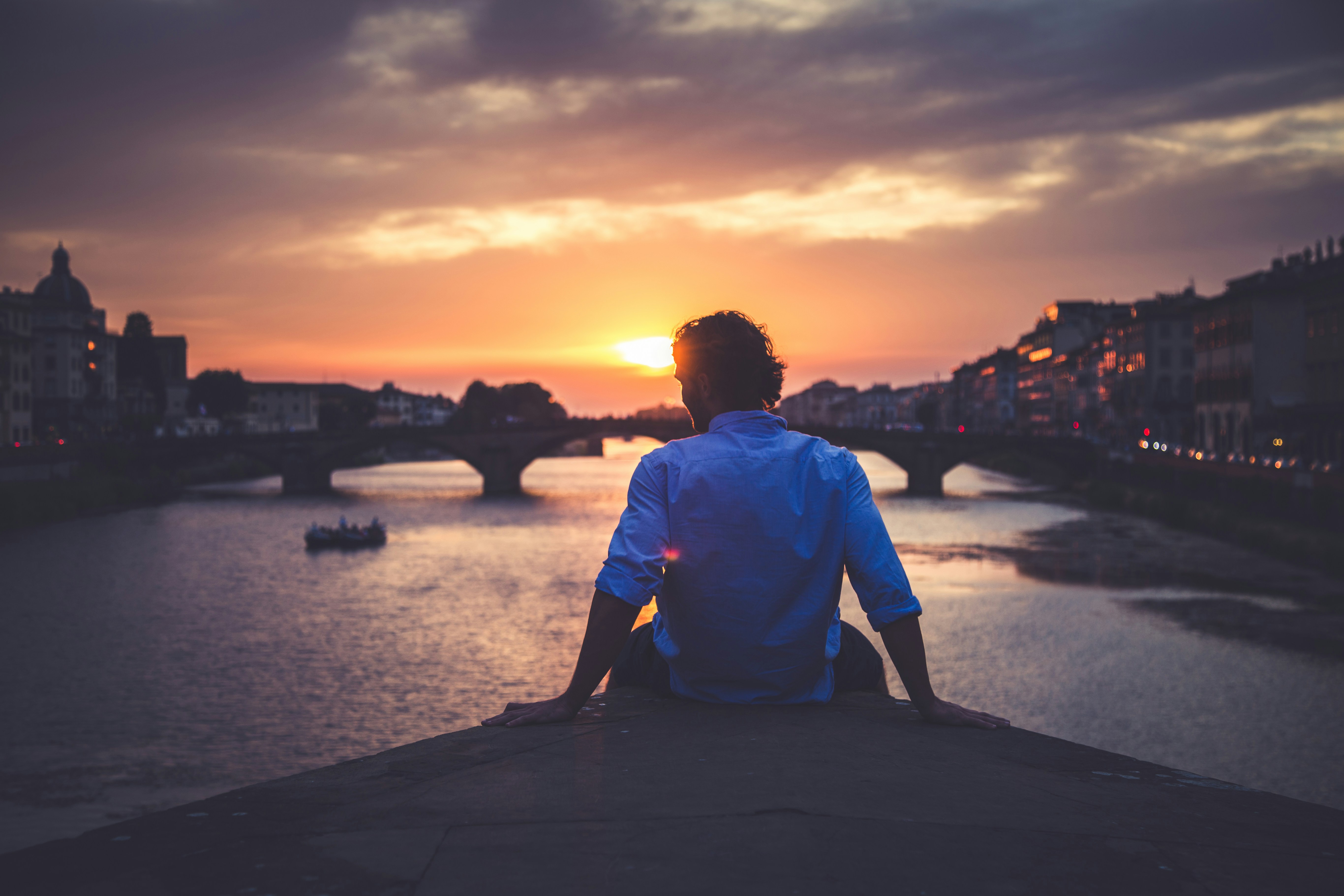 Man Watching Sunset Over River