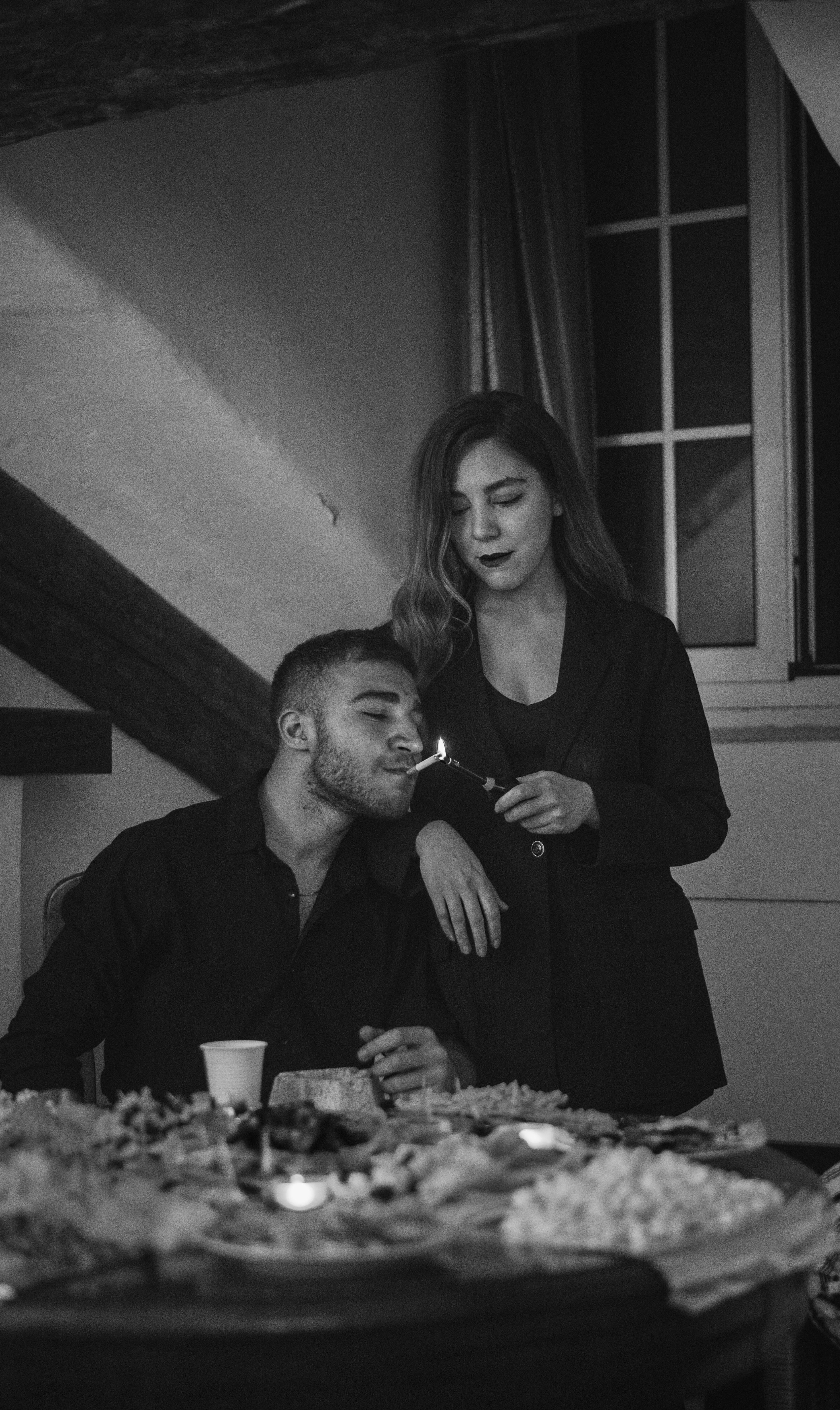 Woman Lighting Cigarette for Man at Dinner