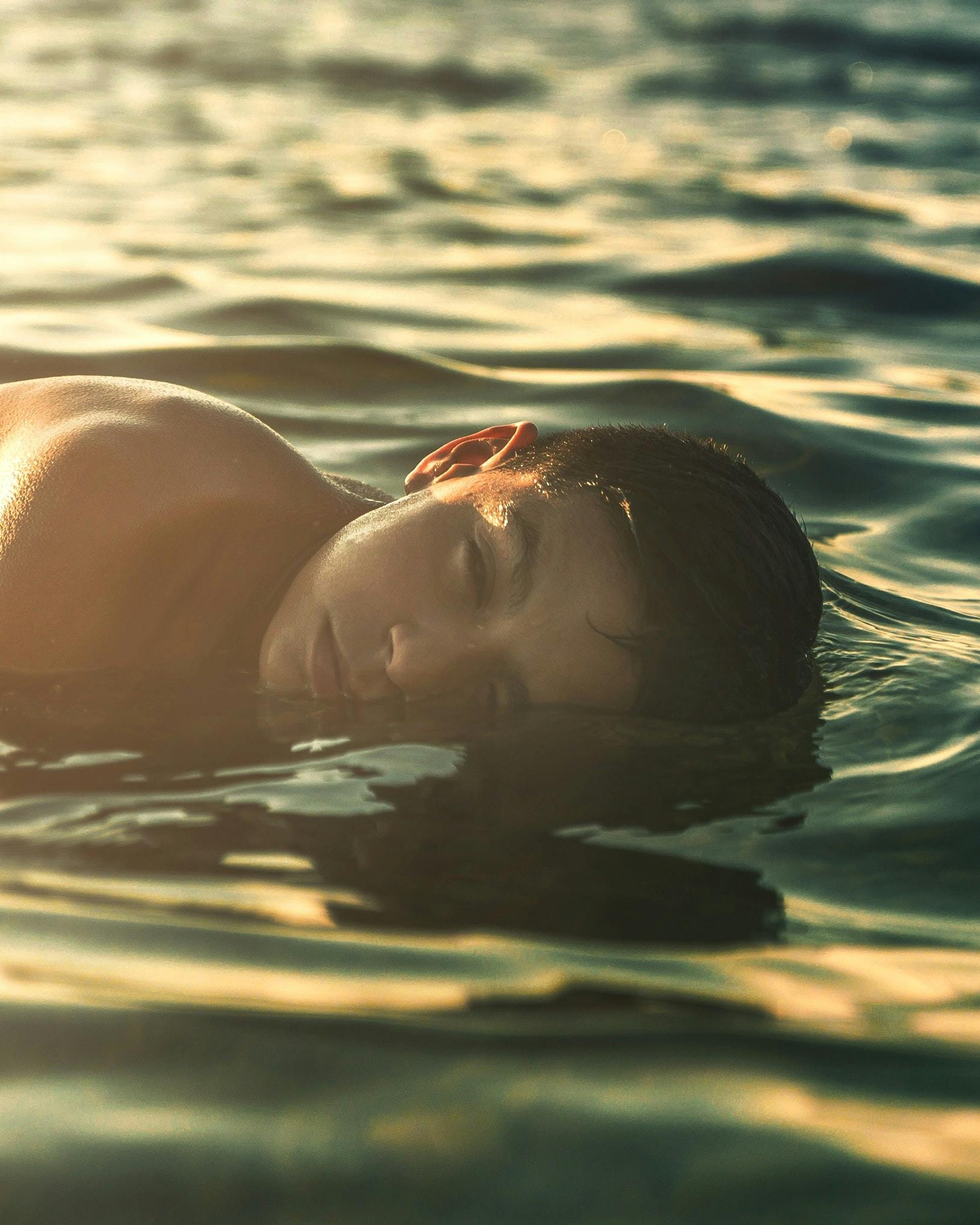 Man Floating in Golden Sunlit Water