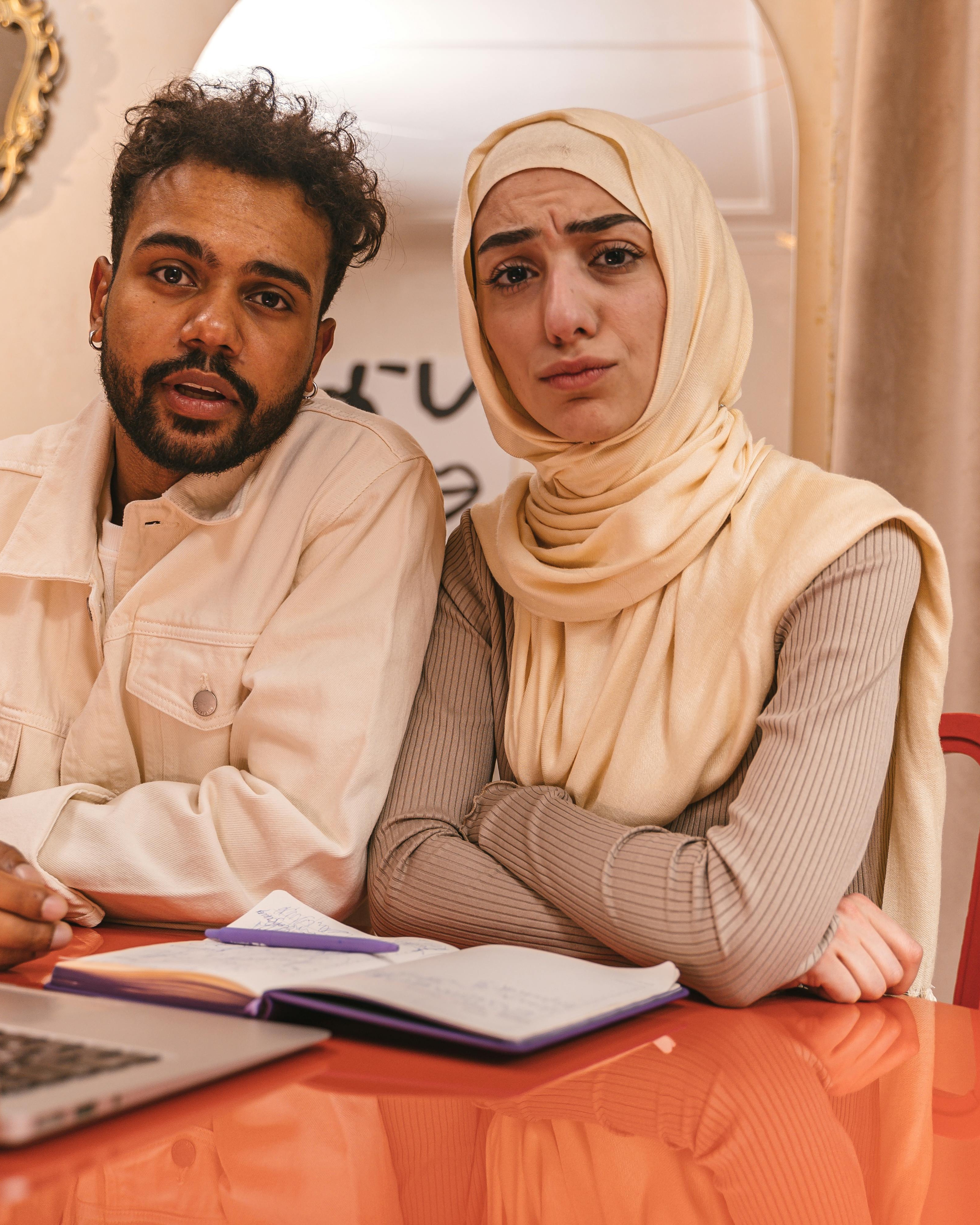 Confused Young Couple Looking At Camera