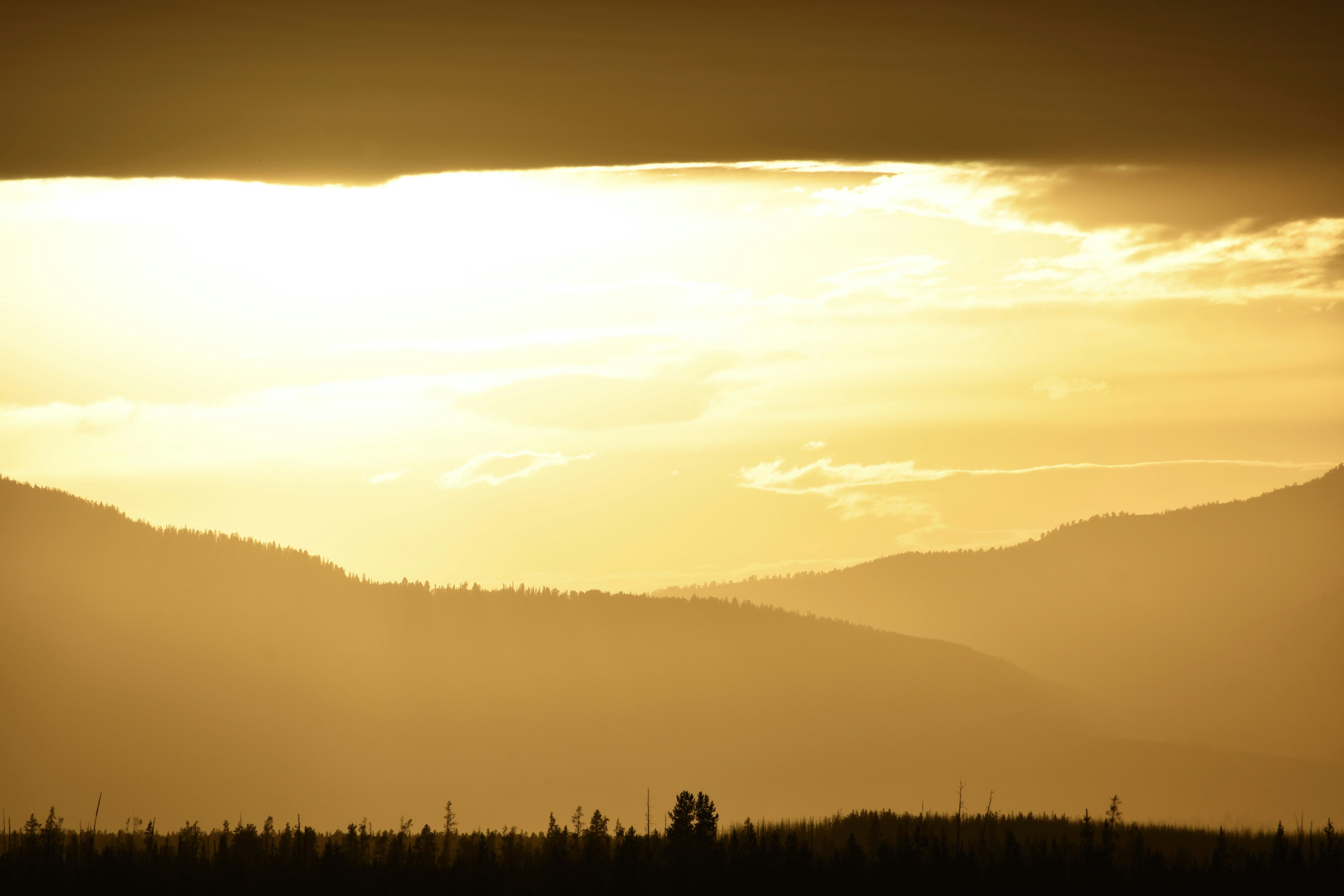 Golden Sunset Over Layered Mountain Forests