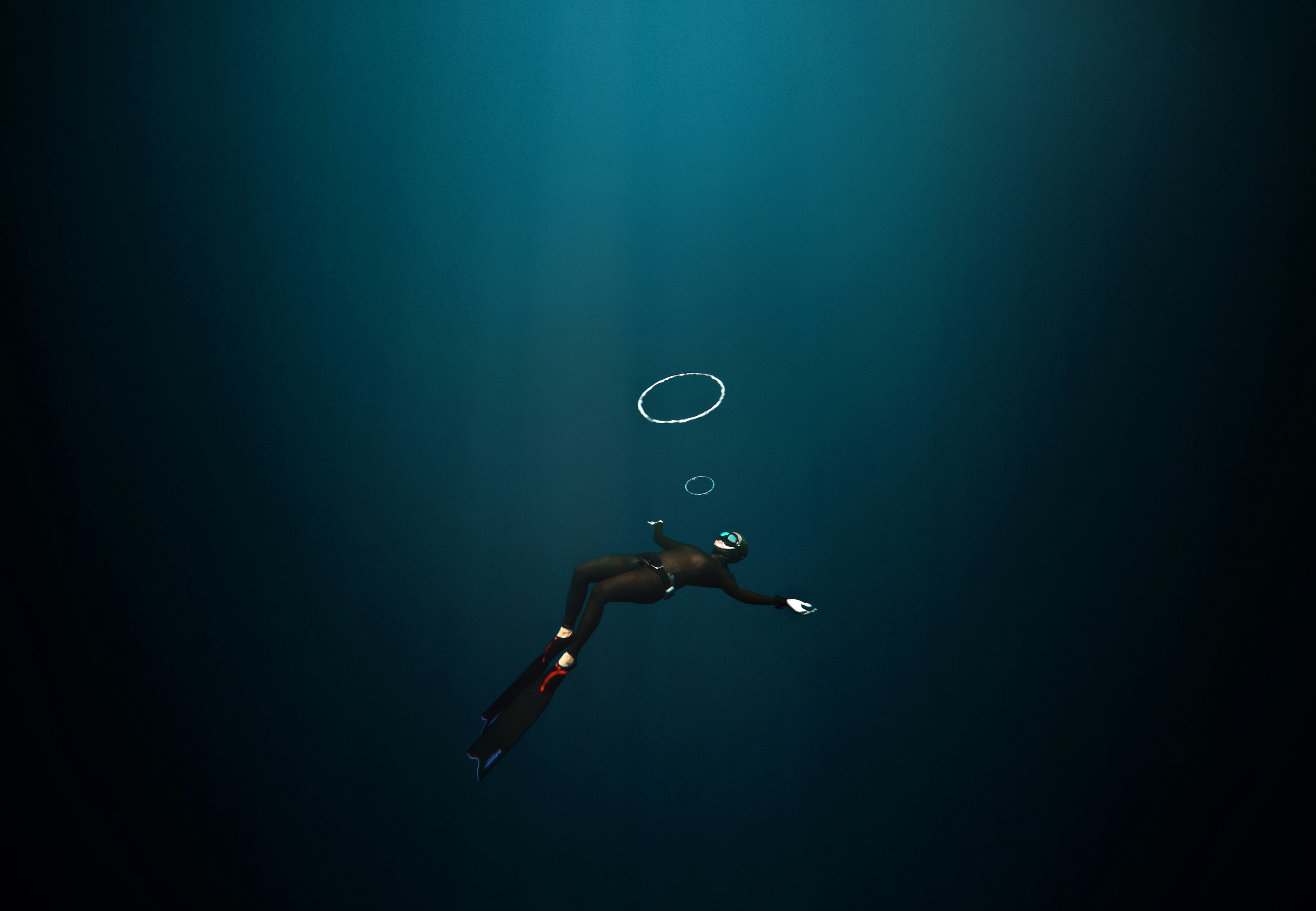 Freediver Chasing Bubble Rings Underwater