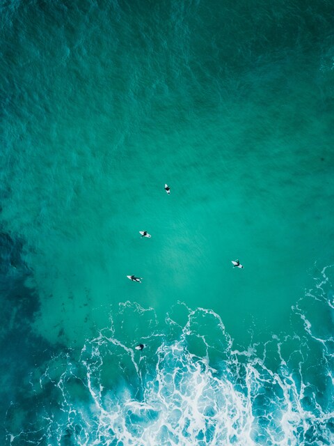 Aerial View of Surfers on Turquoise Sea