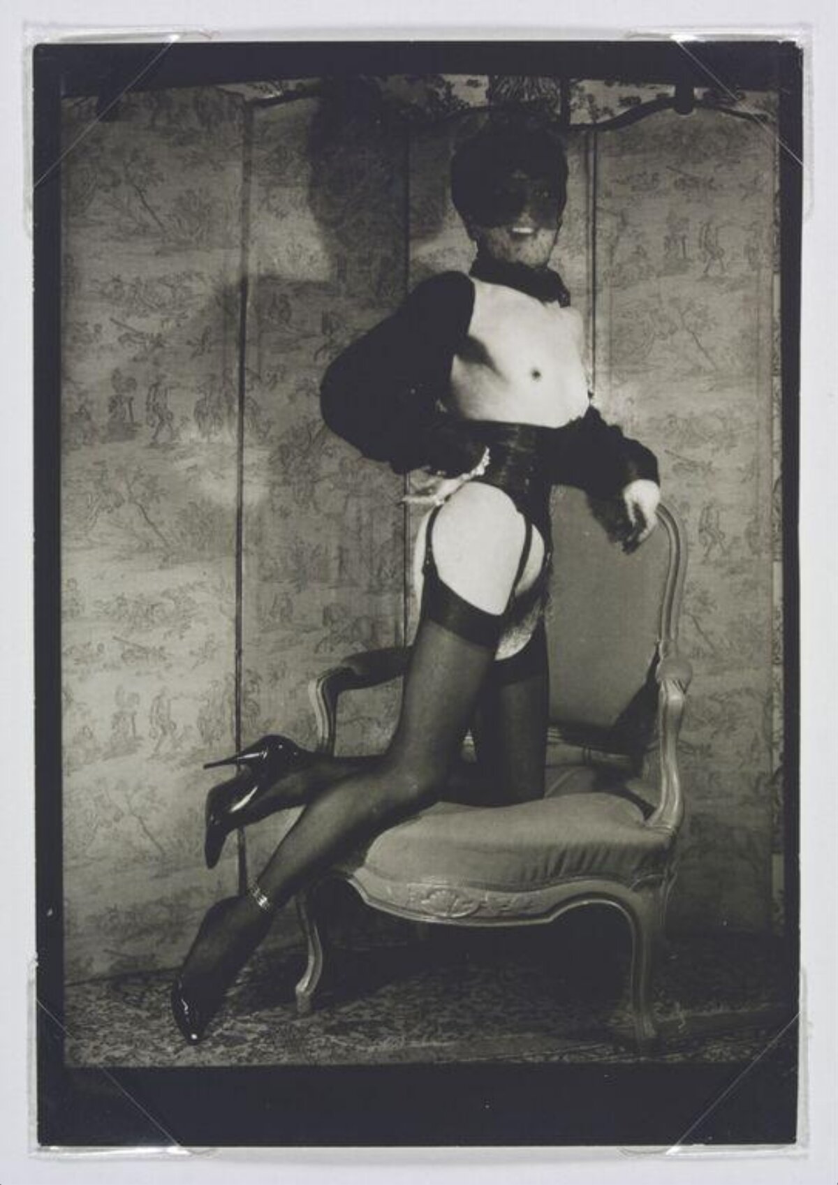 Masked Figure Posing on Armchair