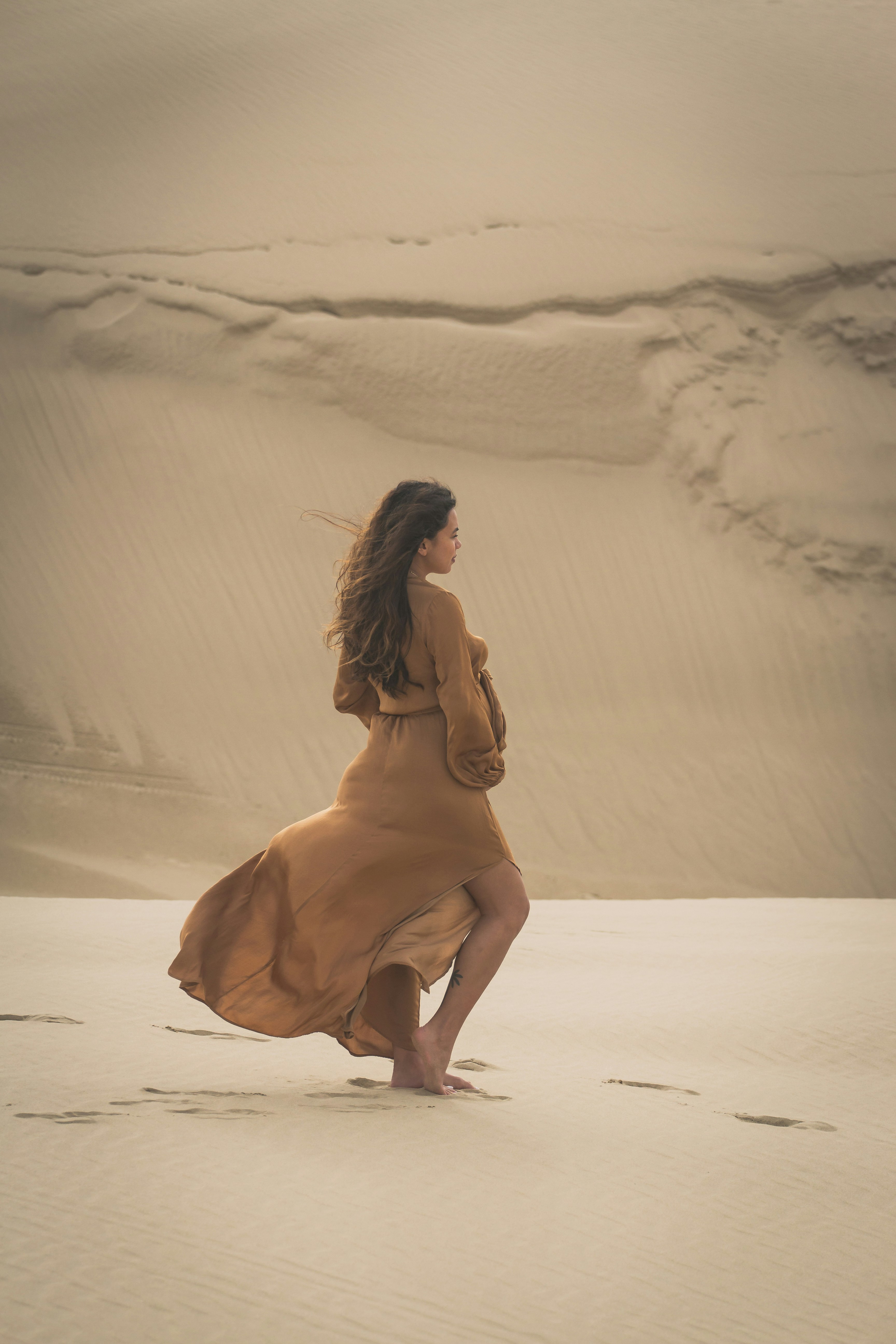 Pregnant Woman Walking in Sand Dunes