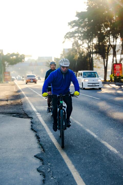 Two Cyclists Riding on Urban Road
