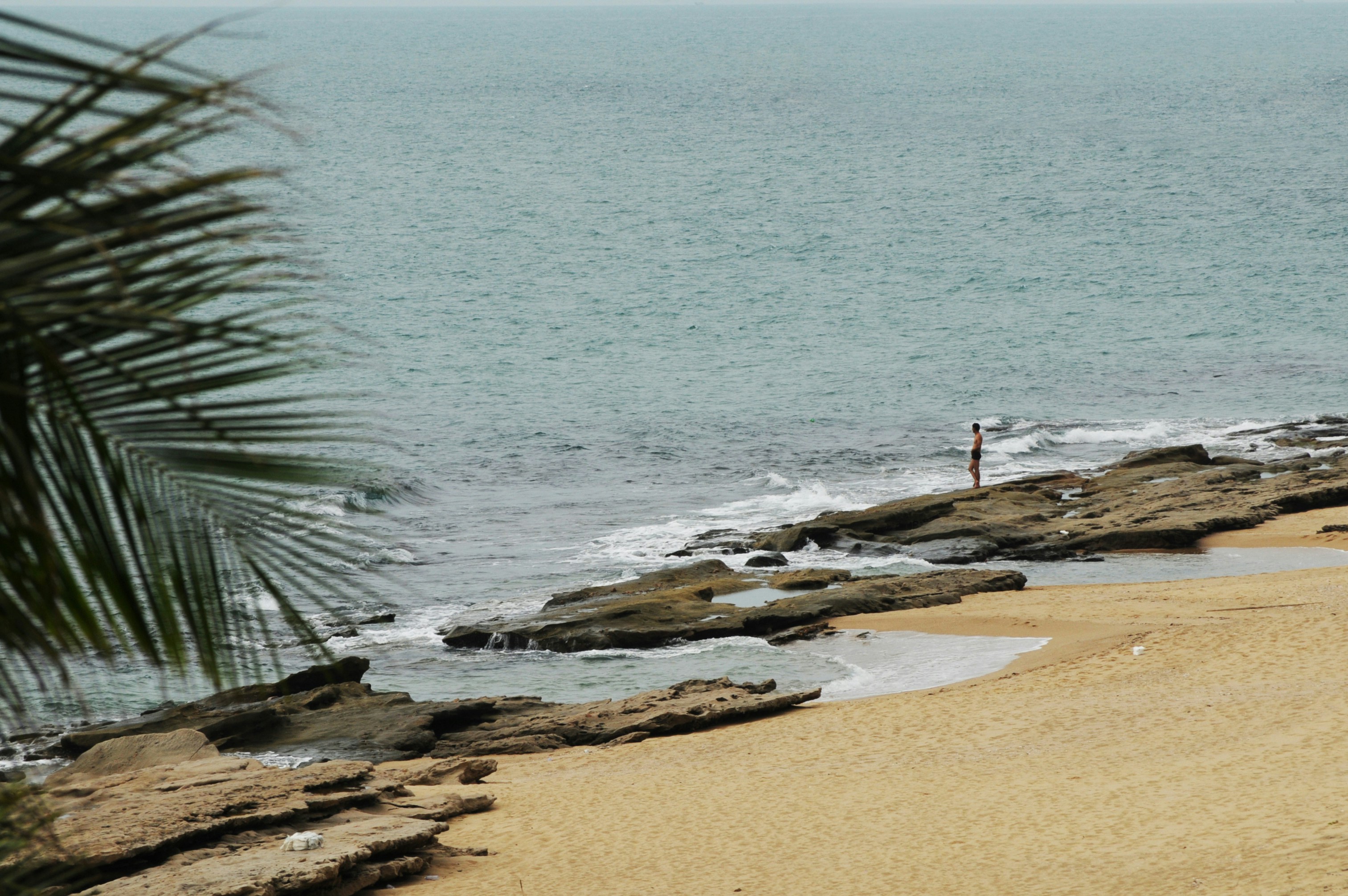 Lone Man at Rocky Seaside Beach