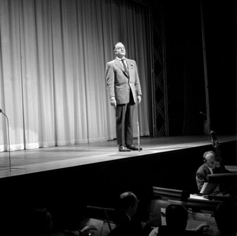 Male Performer on Theater Stage With Orchestra