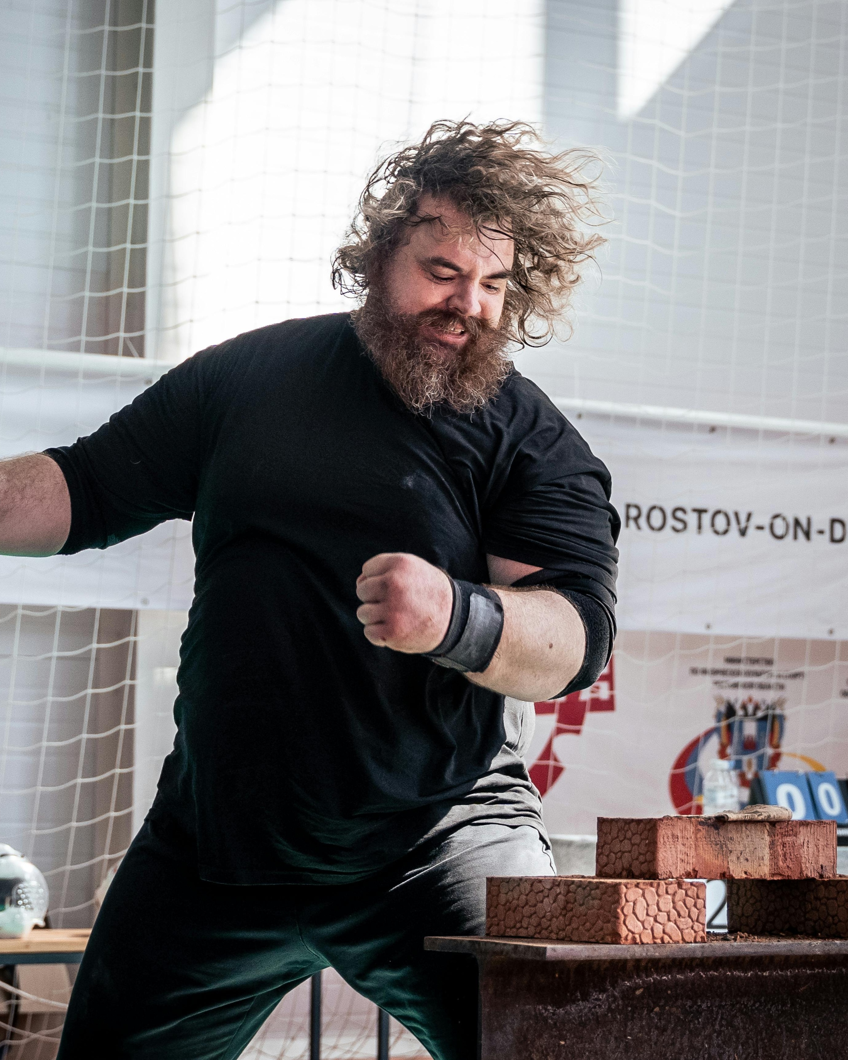 Strongman Breaking Bricks at Competition