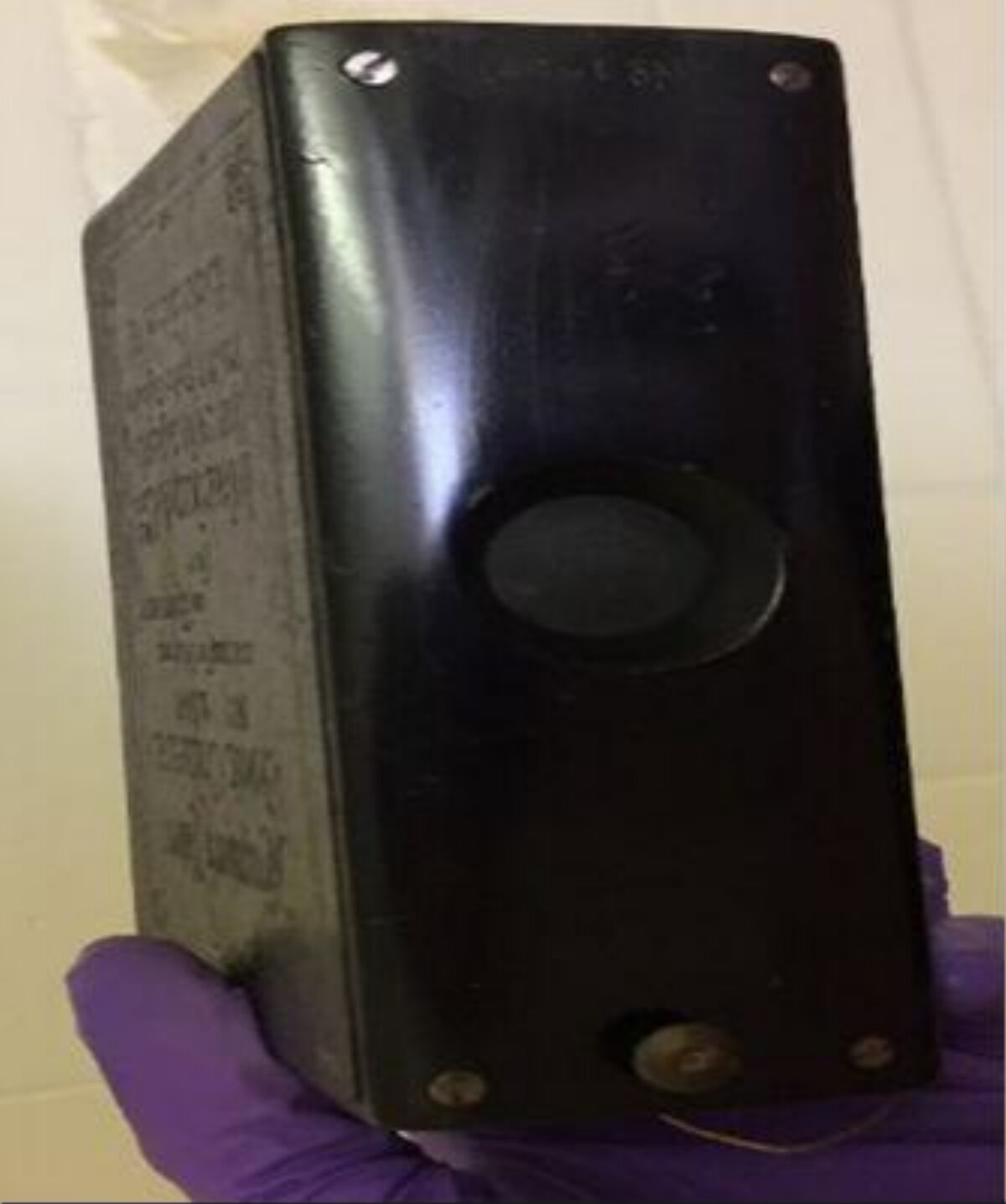 Old Black Electrical Box Held By Gloved Hand