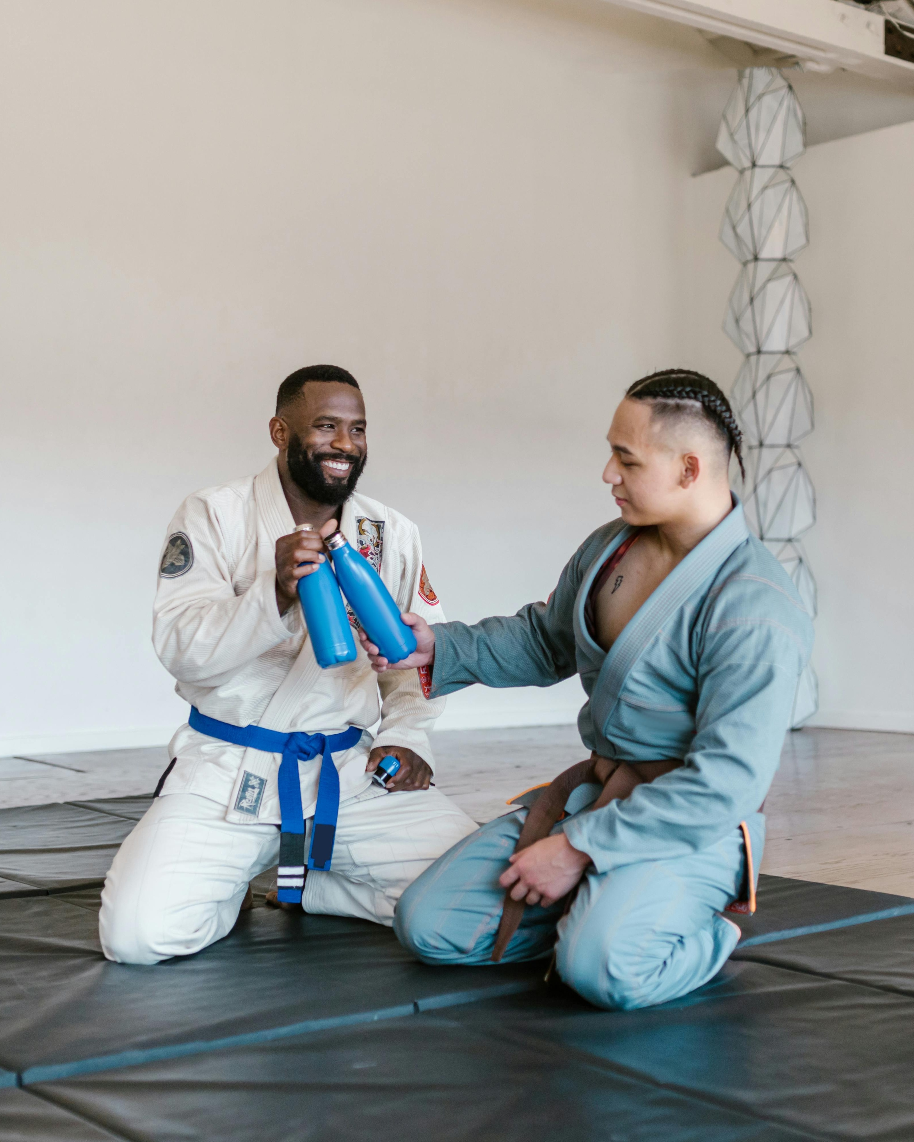 Two Jiu Jitsu Athletes Toasting With Water Bottles