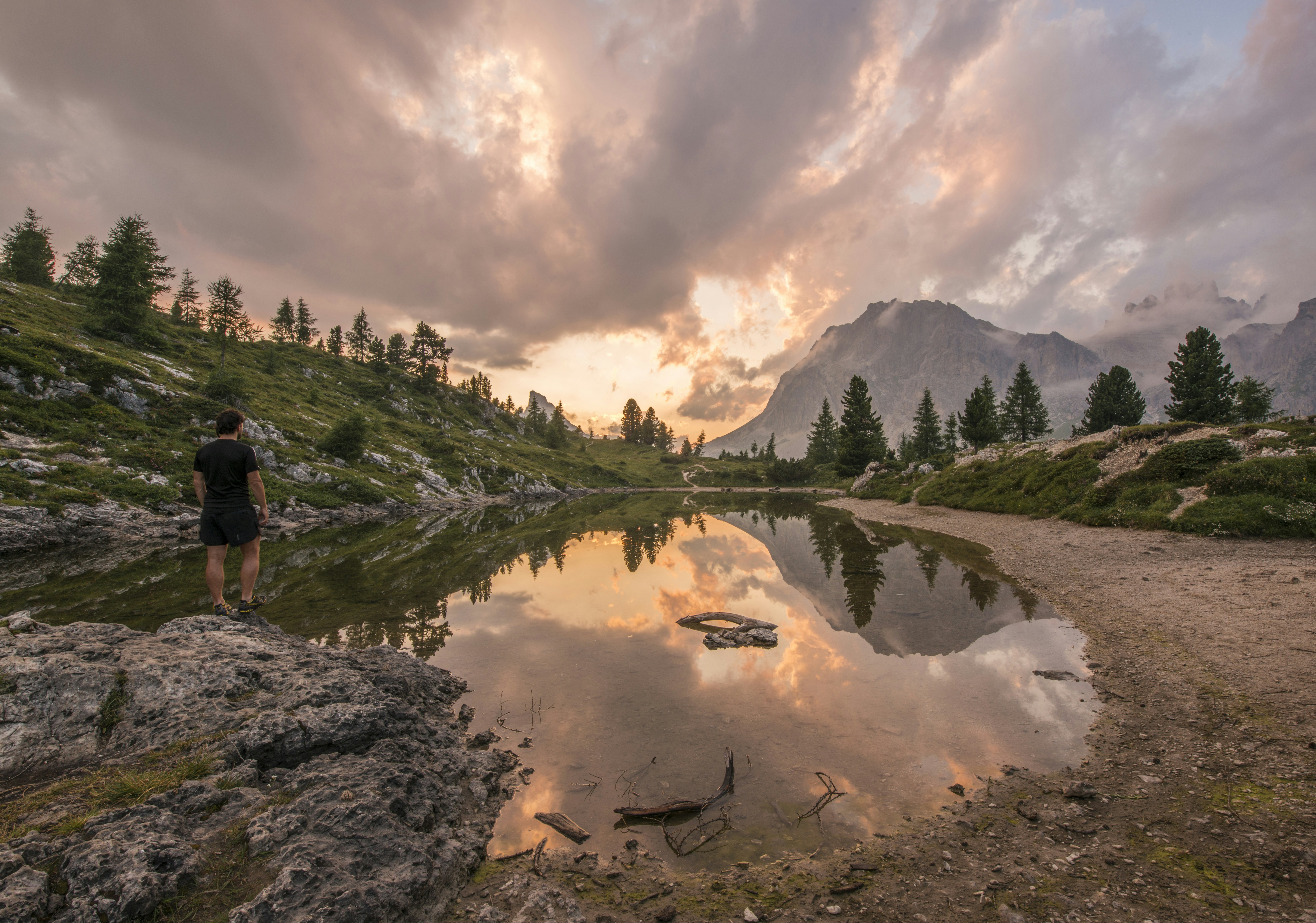 Hiker Watches Sunset at Mountain Lake
