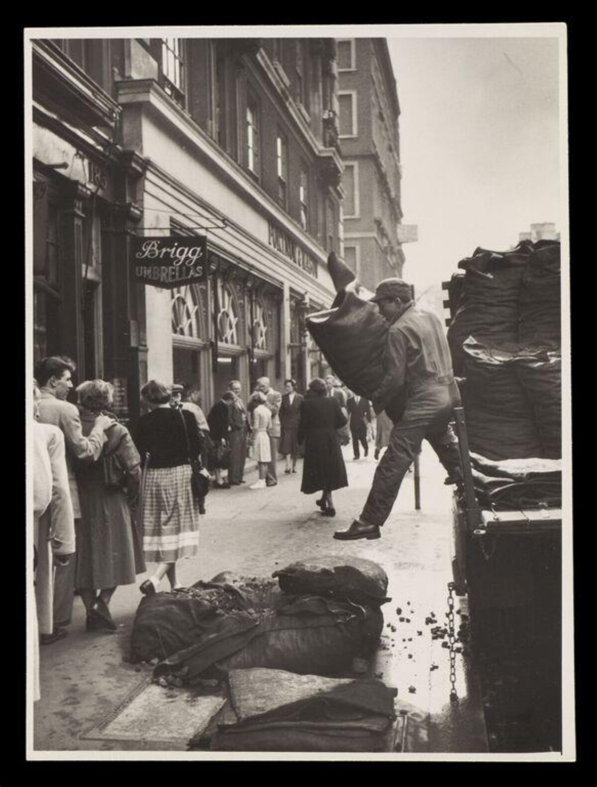 Worker Unloading Coal on City Street