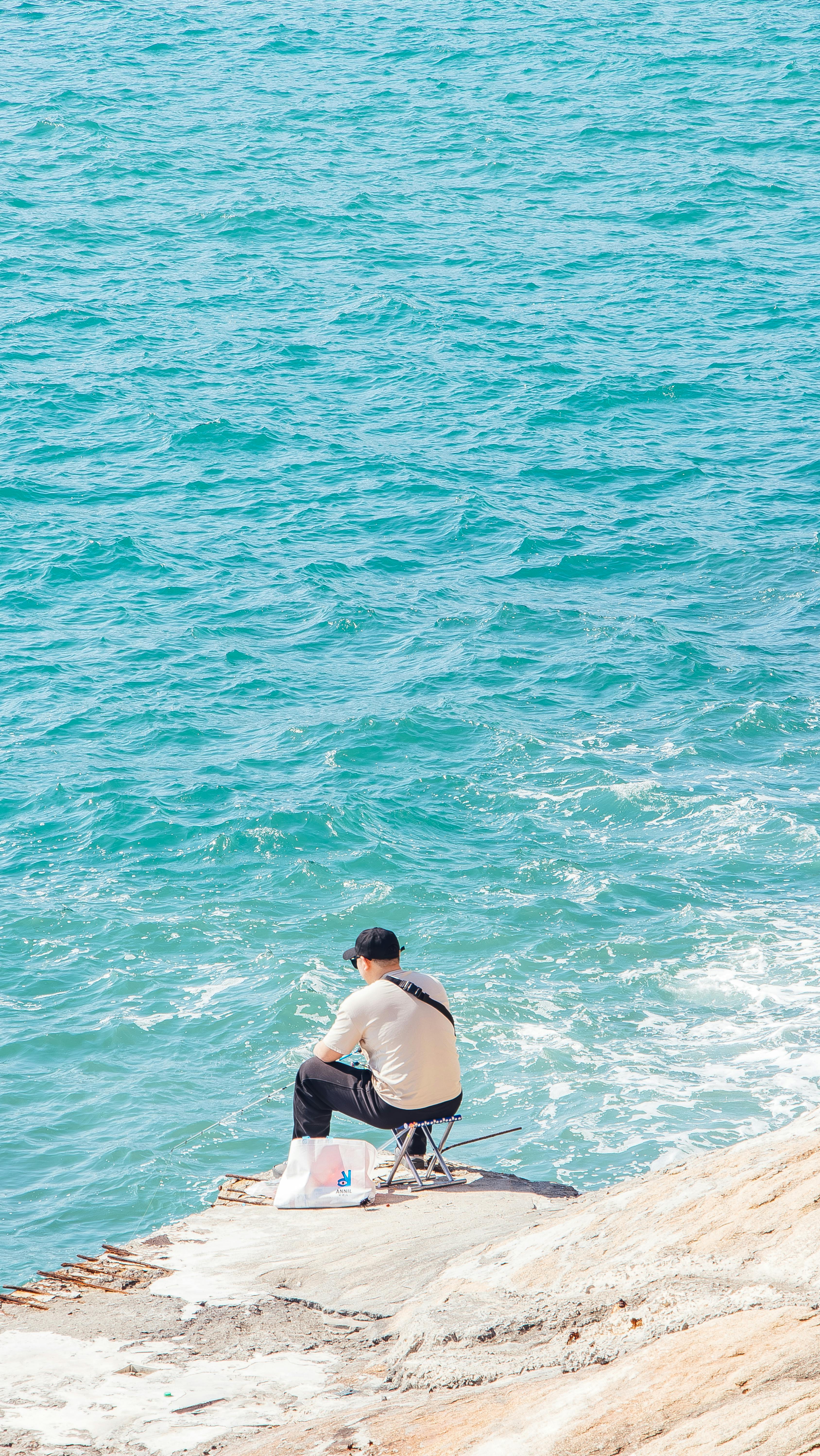 Man Fishing by Turquoise Sea