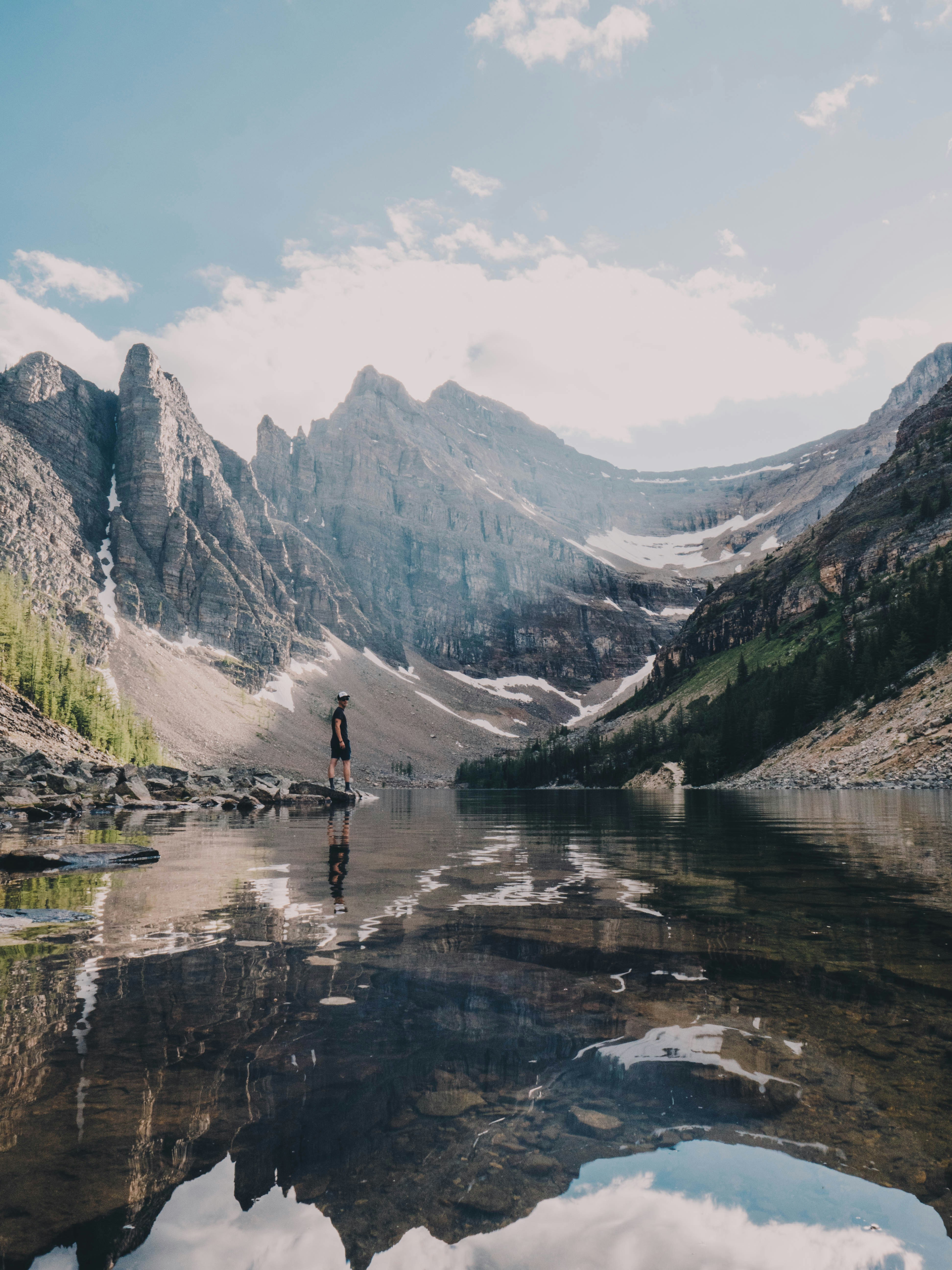 Hiker Standing by Mountain Lake
