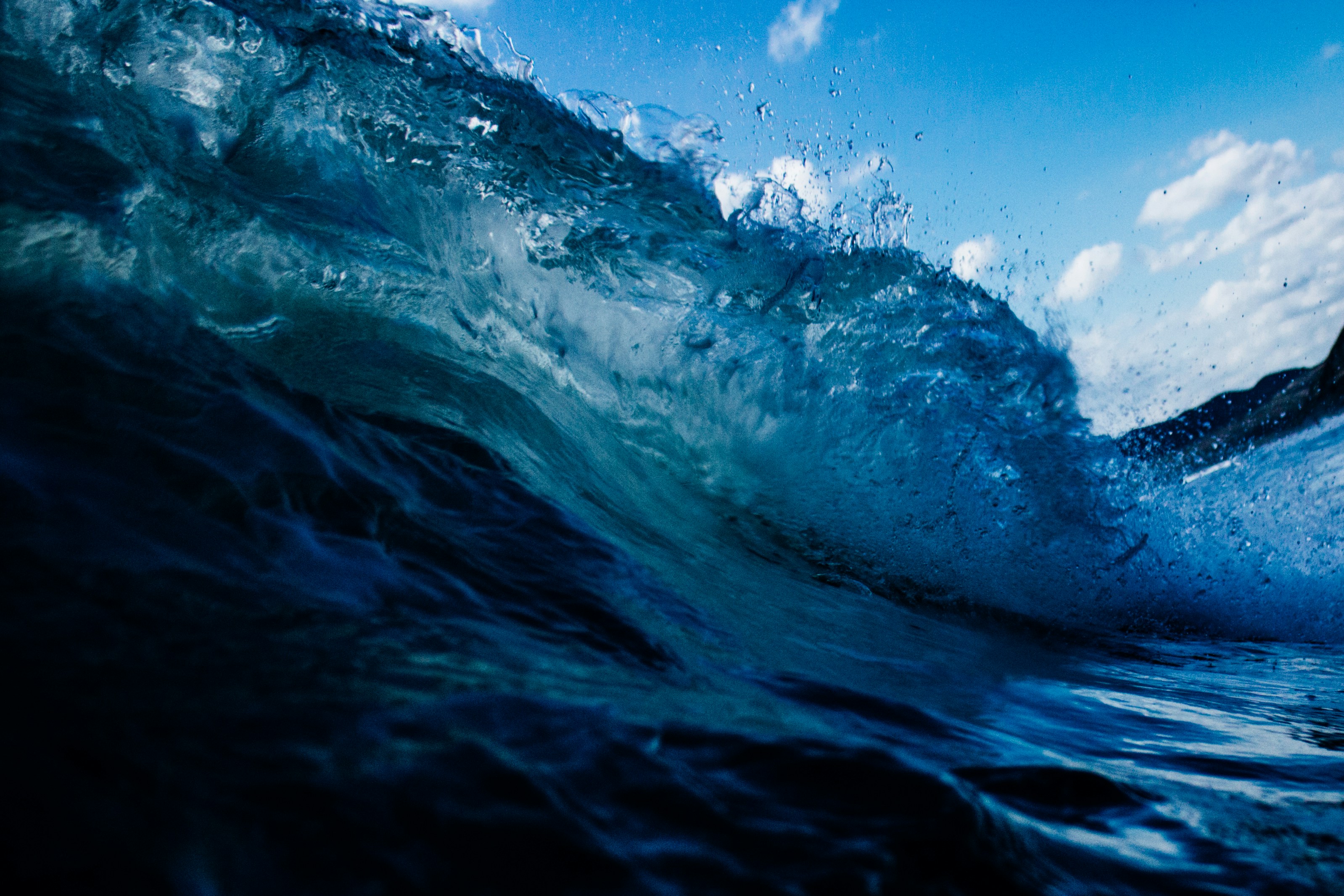 Breaking Ocean Wave Under Blue Sky