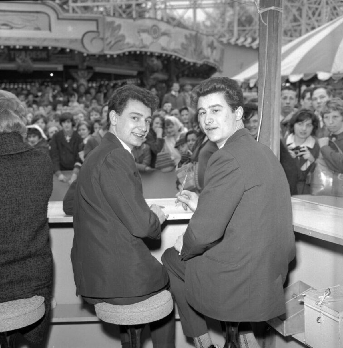 Two Young Men Signing Autographs at Fairground