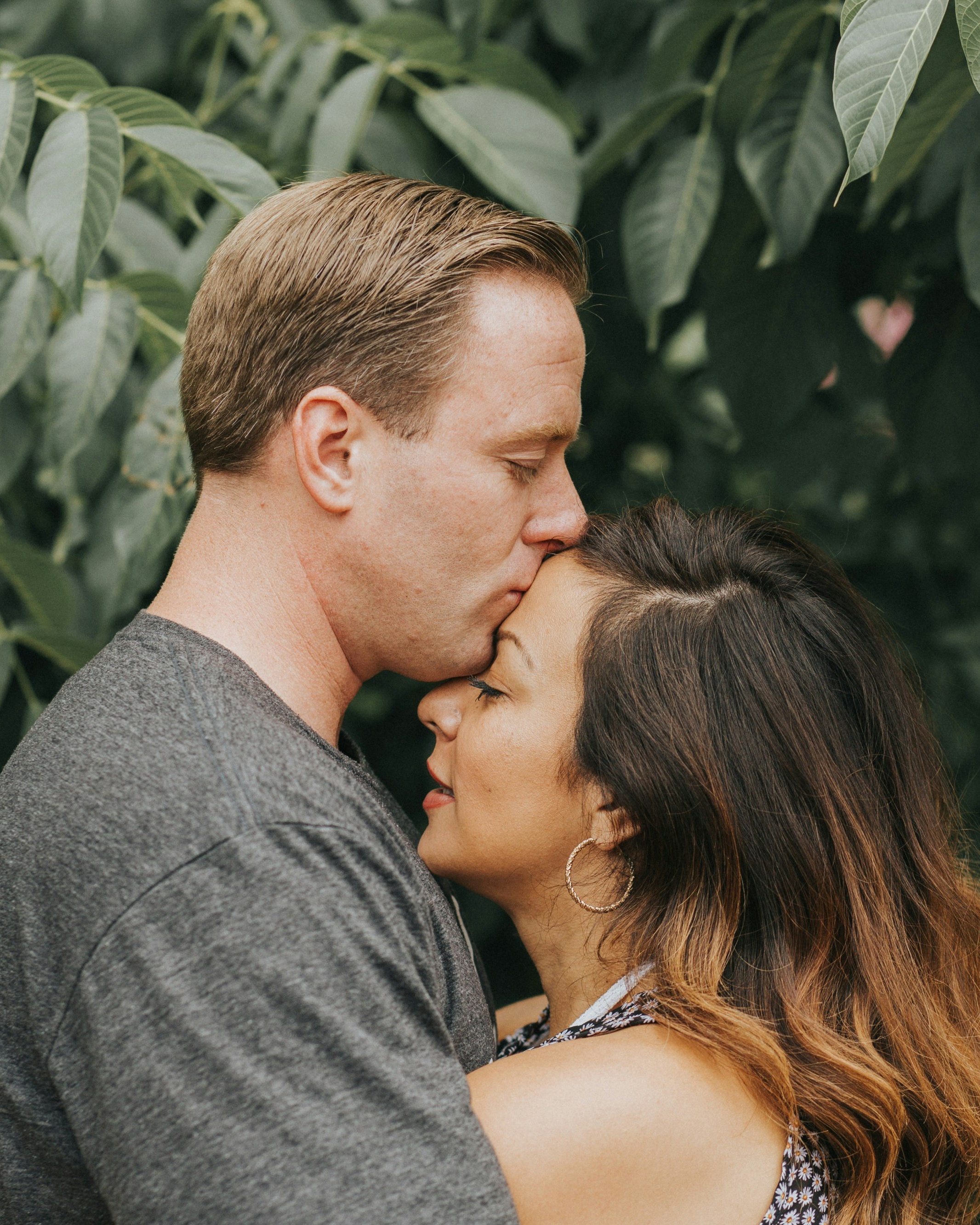 Man Kissing Woman's Forehead Outdoors