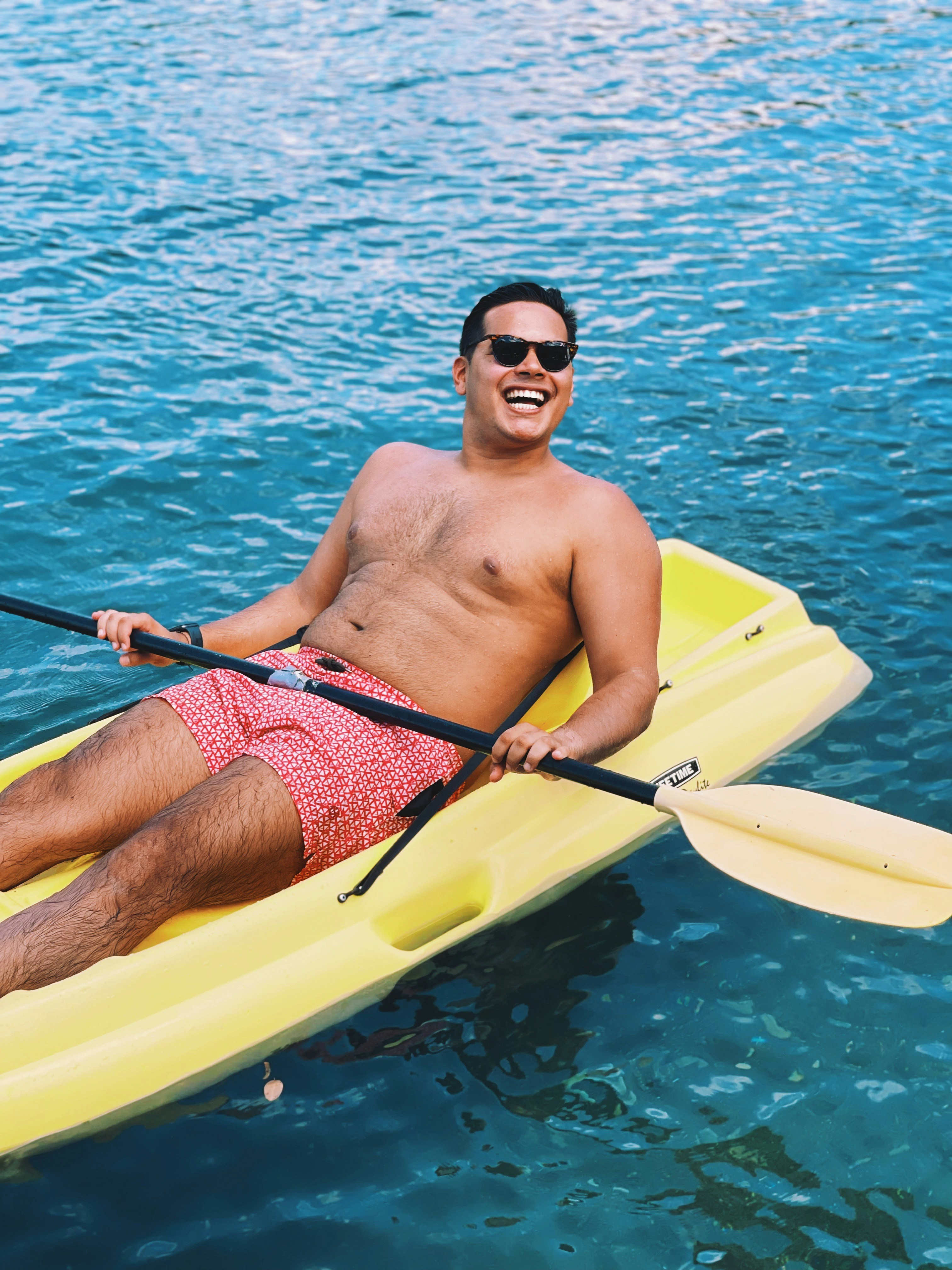 Smiling Man Kayaking on Blue Water