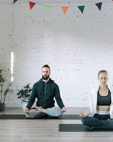 Two People Meditating in Yoga Class