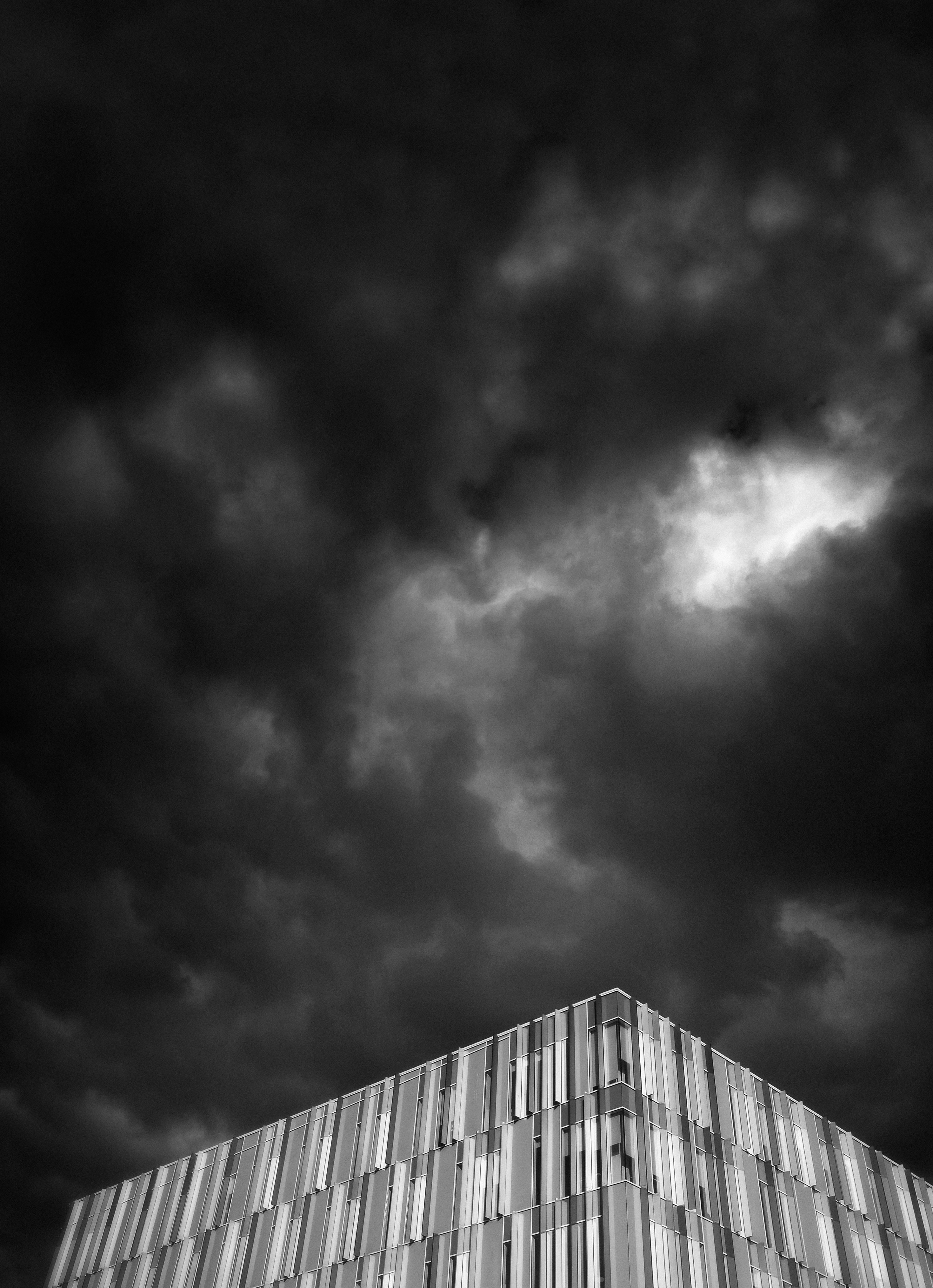 Modern Building Under Dramatic Cloudy Sky — Minimal Wallpapers