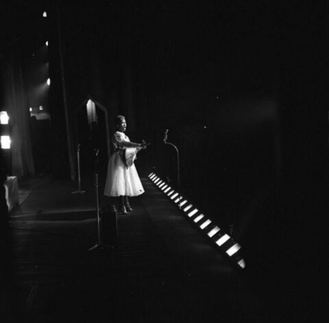 Female Performer with Guitar on Stage