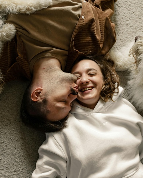 Happy Couple Lying With Fluffy Dog