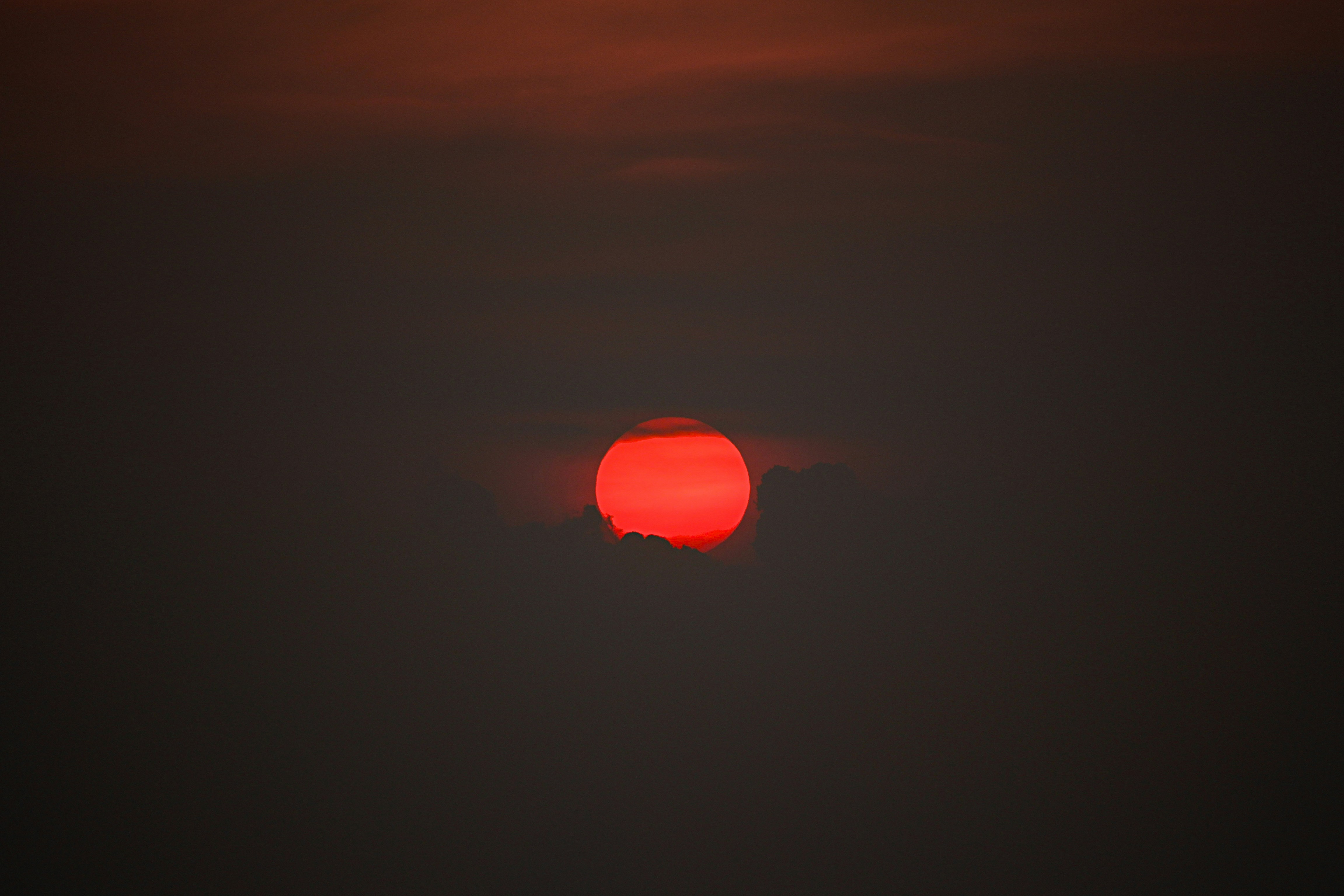 Red Sun Obscured by Dark Clouds