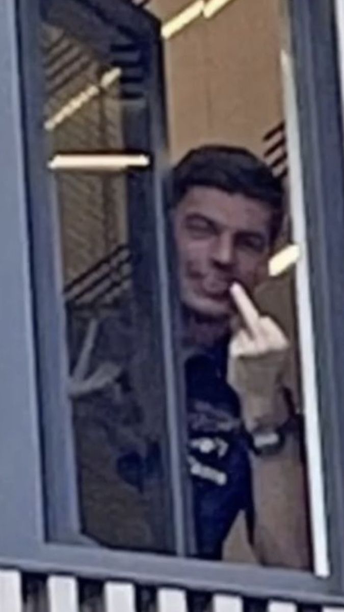 Man Gesturing Behind Window