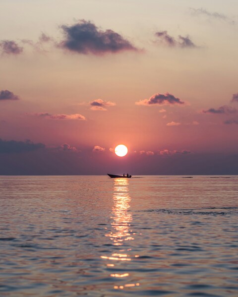 Sunset on Sea with Small Boat