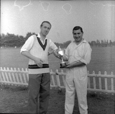 Two Men Posing With Trophy